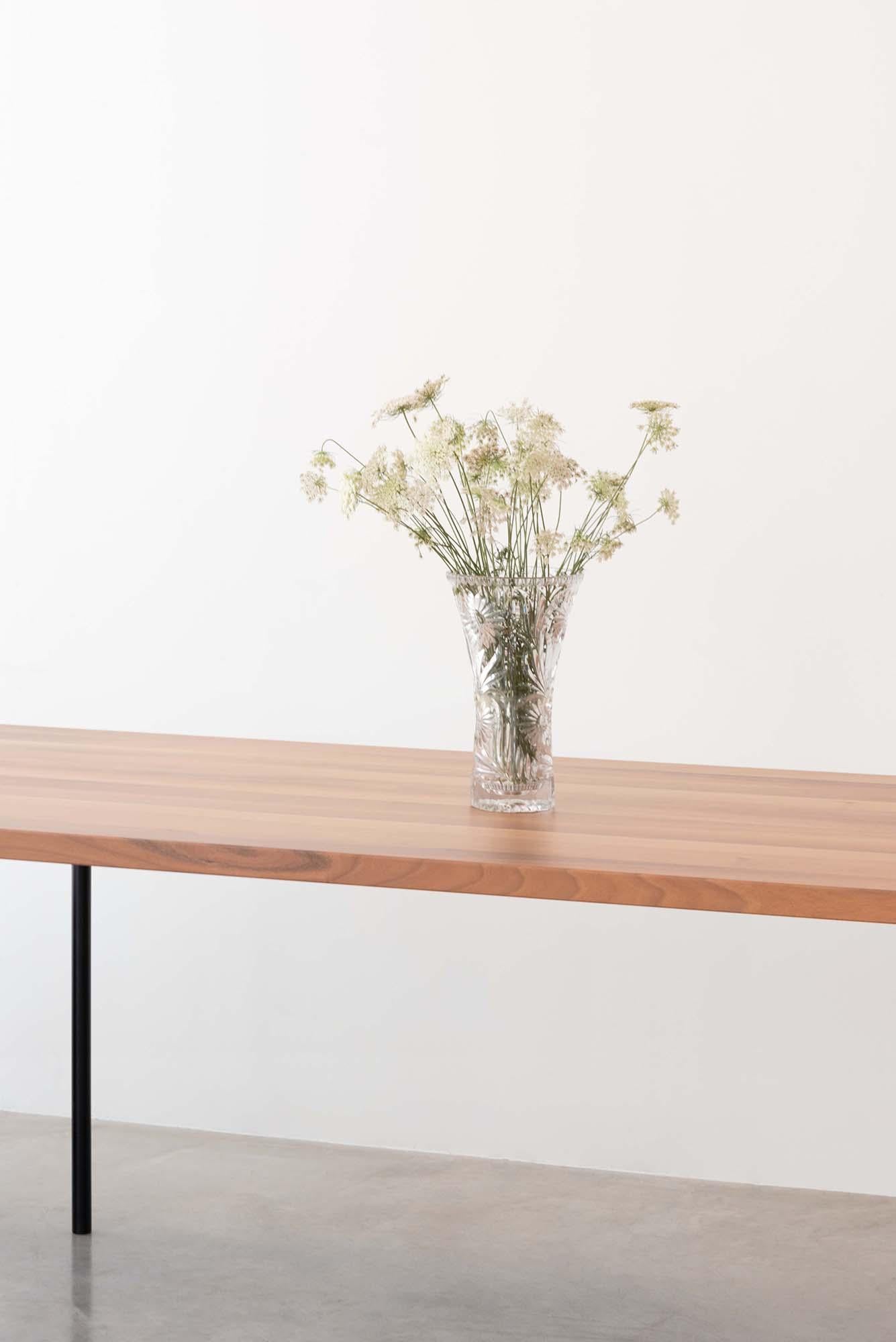 Quatre fins pieds en métal peint soutiennent un solide plateau en noyer européen.
De forme rectangulaire, la table garde un design simple avec une ligne naïve et rigoureuse.

Concepteur : Roberto Cicchinè.
 