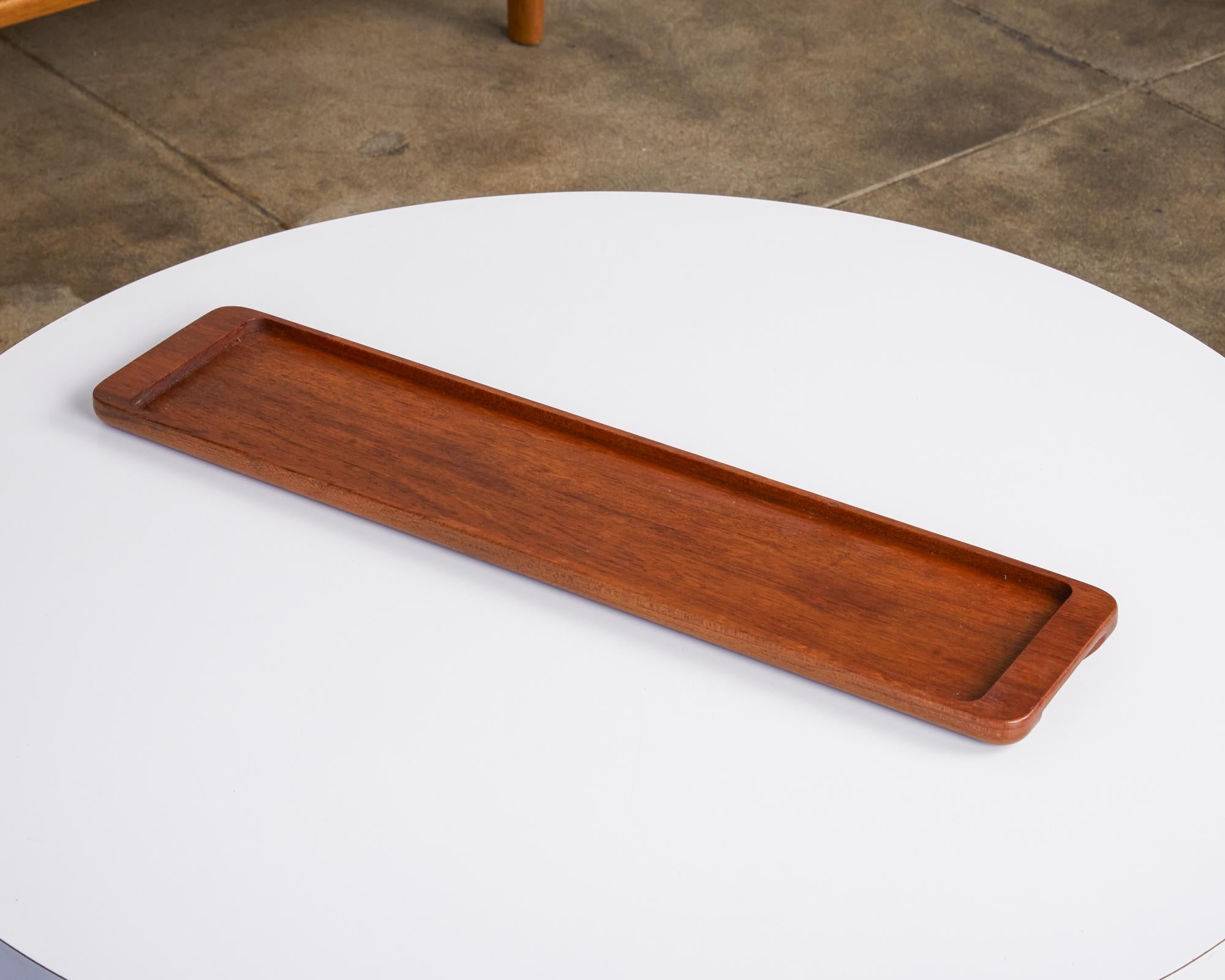 Rectangular teak serving tray by ESA Denmark, circa 1960s. The slender tray features raised edges with an inset middle section perfect for serving your favorite cheese and crackers. The narrow ends feature a cut out section underneath that is meant