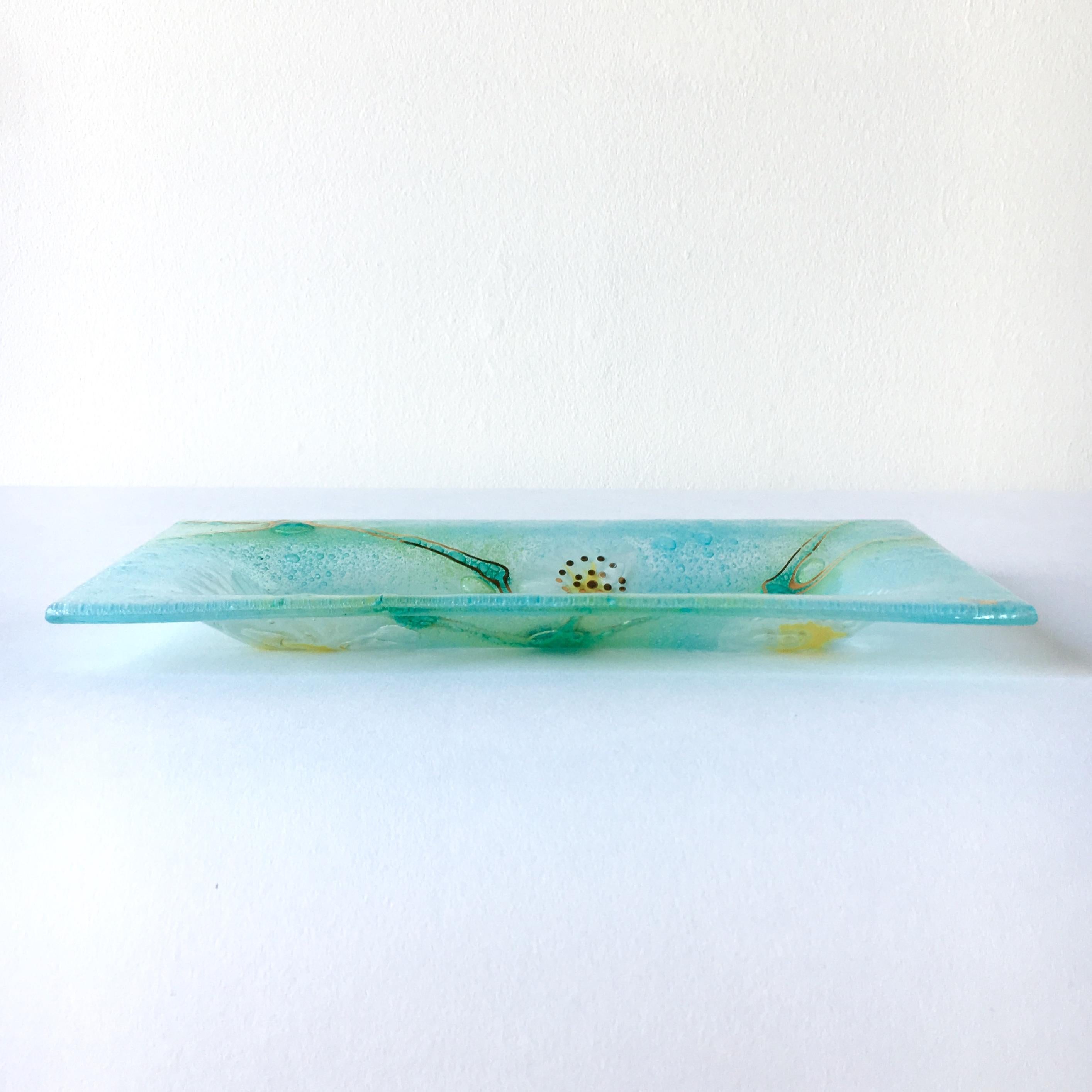A rectangular Thistledown fused art glass plate by Higgins signed 1957-1965

Michael Higgins (1908-1999) and Frances Higgins(1912-2004) met in Chicago and were married in 1948. They had a fascination of modern glass fusing. Their works appeared in