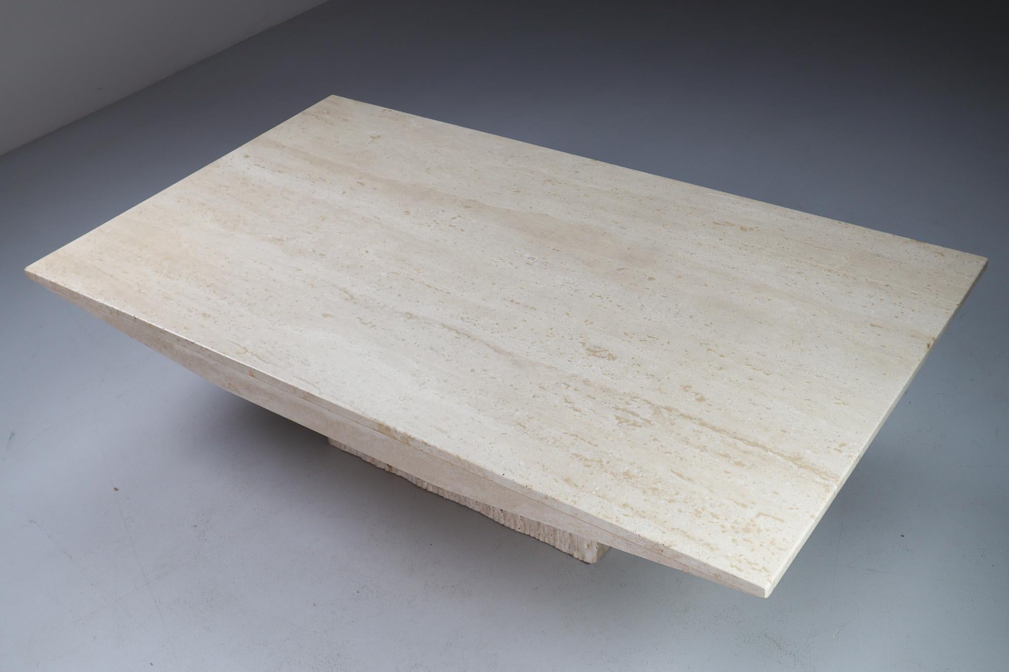 A refined travertine coffee table with rectangular top and square base made in Italy, 1970's. Thick proportions accentuate the weight of the stone, at a convenient 17” inch height. A material rich in itself, echoing classical sculpture. Associations