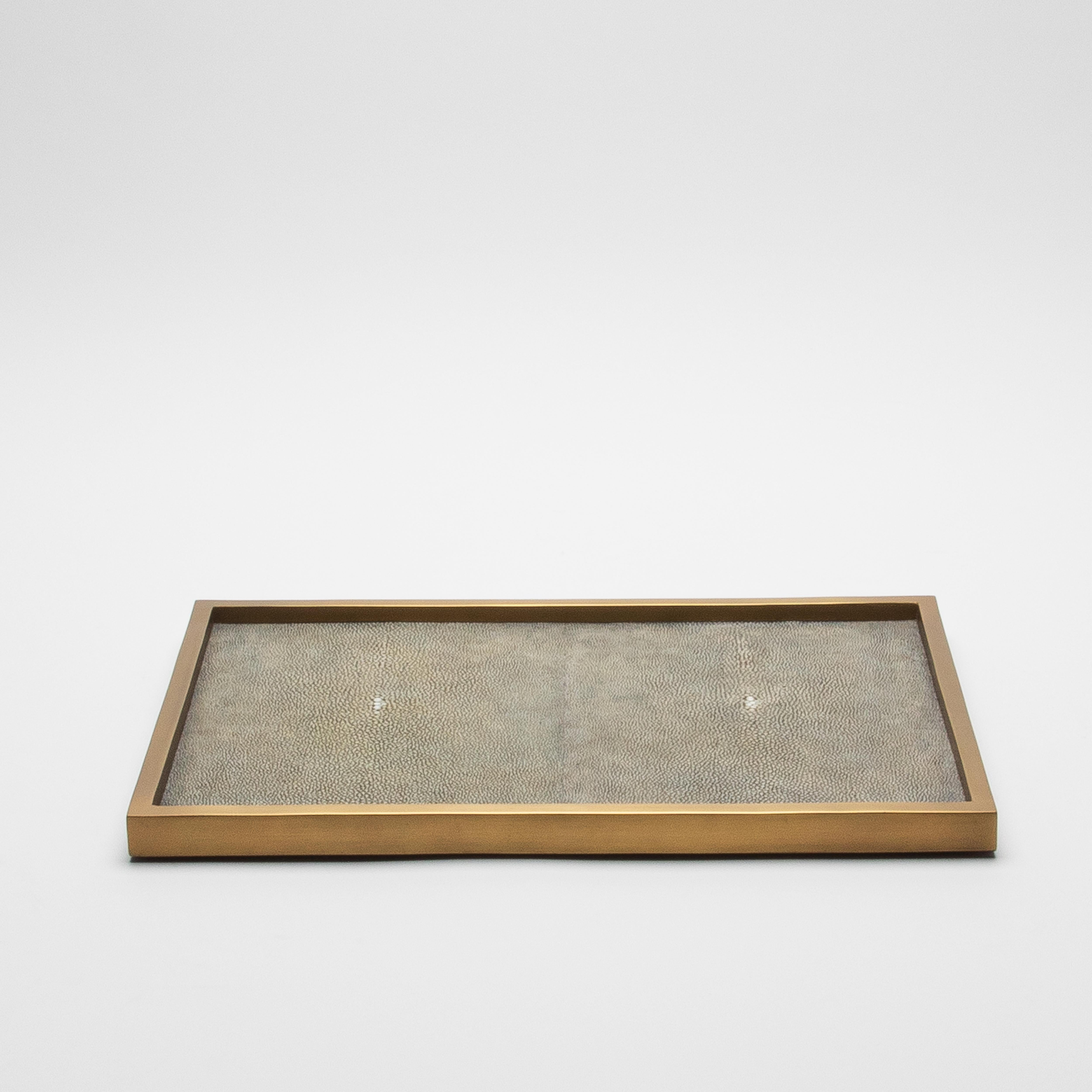 The Rectangular Tray in Grey Shagreen with Bronze Patina Brass by Kifu Paris is an epitome of understated elegance, designed to captivate with its simplicity and luxurious materials. Handcrafted with meticulous attention to detail, the tray features