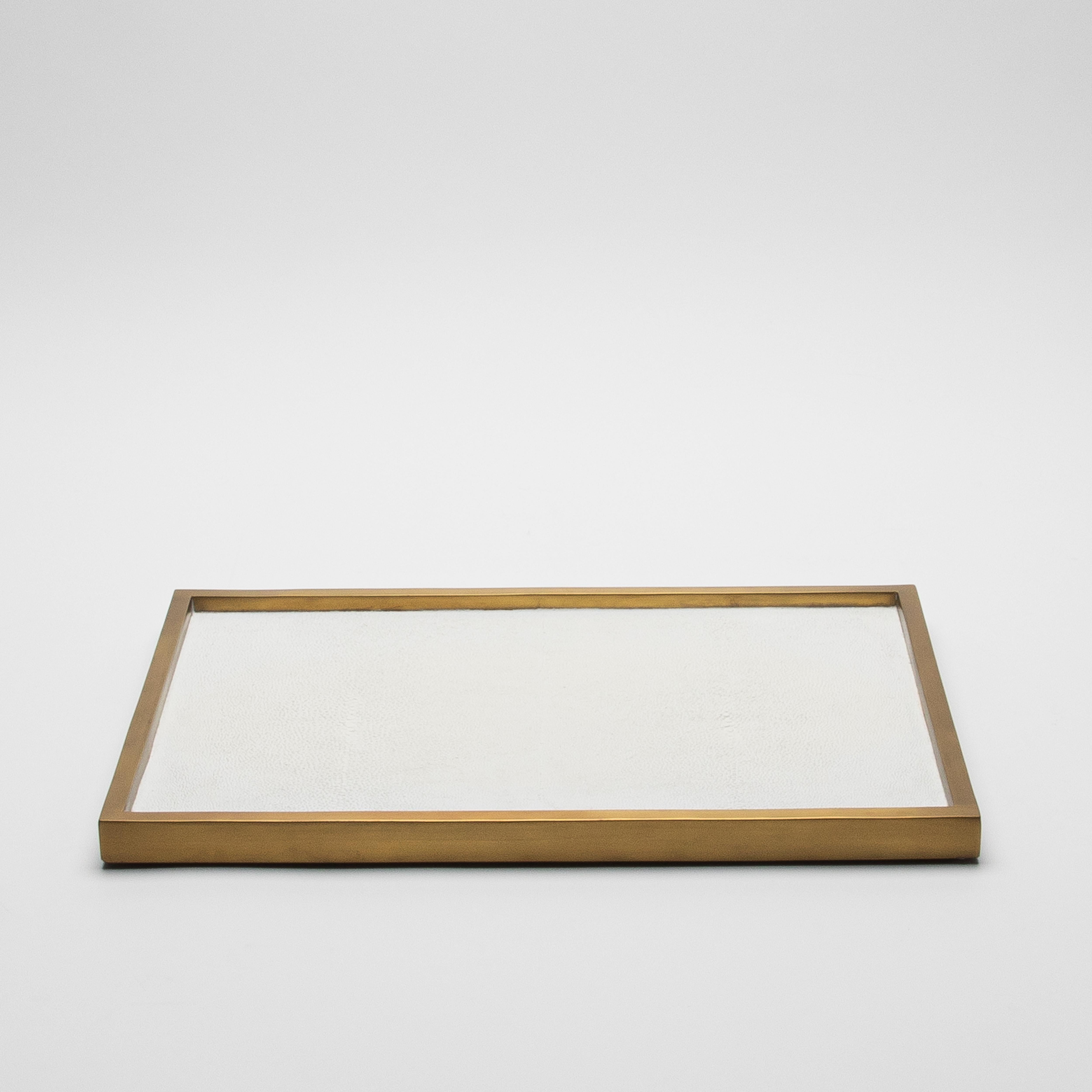 The Rectangular Tray in White Shagreen with Bronze Patina Brass by Kifu Paris is an epitome of understated elegance, designed to captivate with its simplicity and luxurious materials. Handcrafted with meticulous attention to detail, the tray