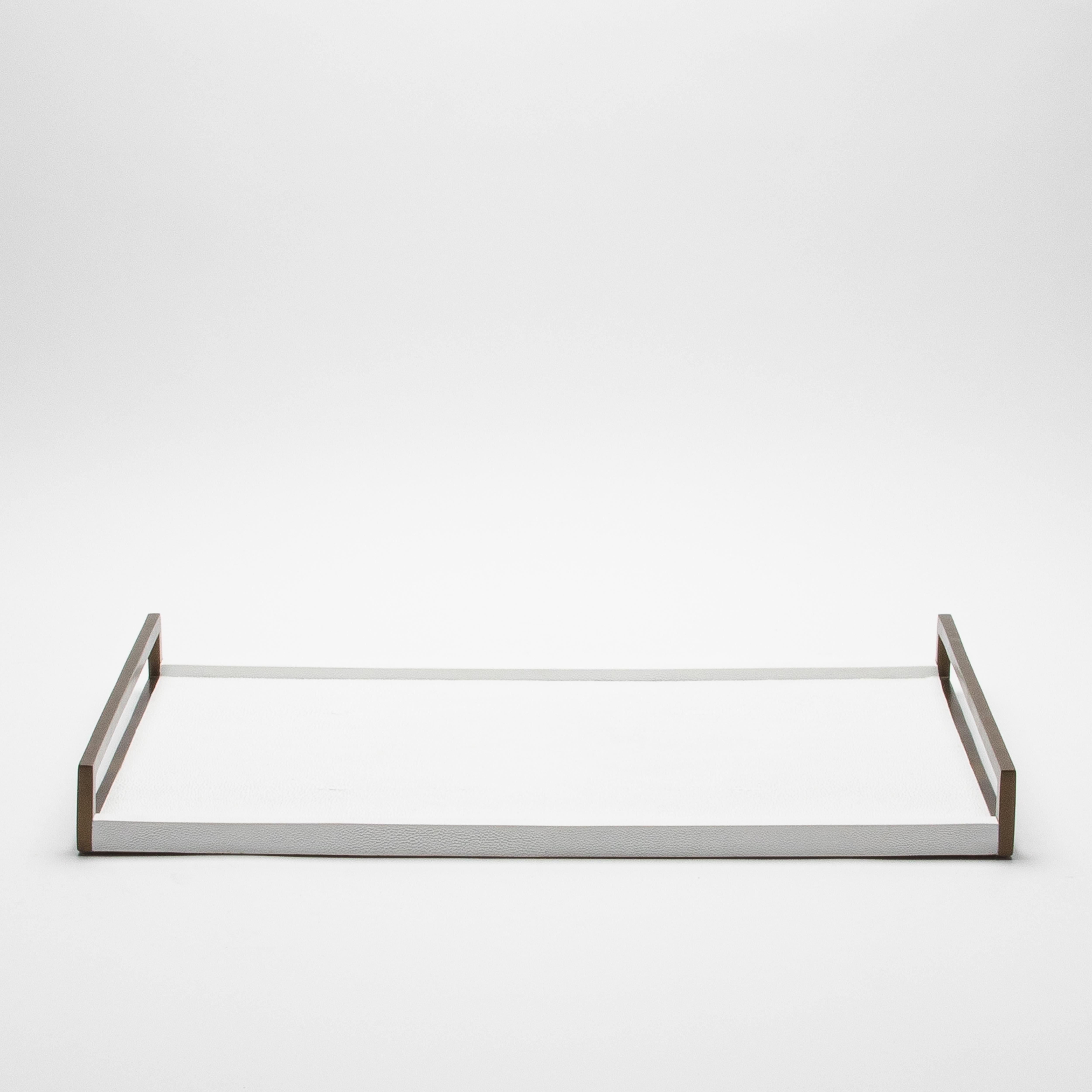 This elegant rectangular tray by R&Y Augousti is a stunning display of luxurious craftsmanship. With its sleek white shagreen surface, it exudes sophistication, while the contrasting bronze patina brass handles add a touch of opulence. Every detail