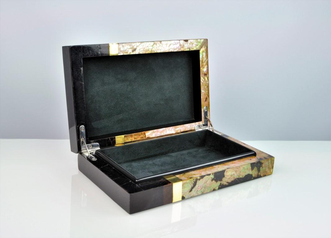 Cette boîte à bijoux est fabriquée à la main avec une marqueterie de coquillages et des garnitures en laiton.

La boîte est munie de charnières et l'intérieur est doublé d'un microsuède noir de haute qualité.

Une pièce très unique que vous ne