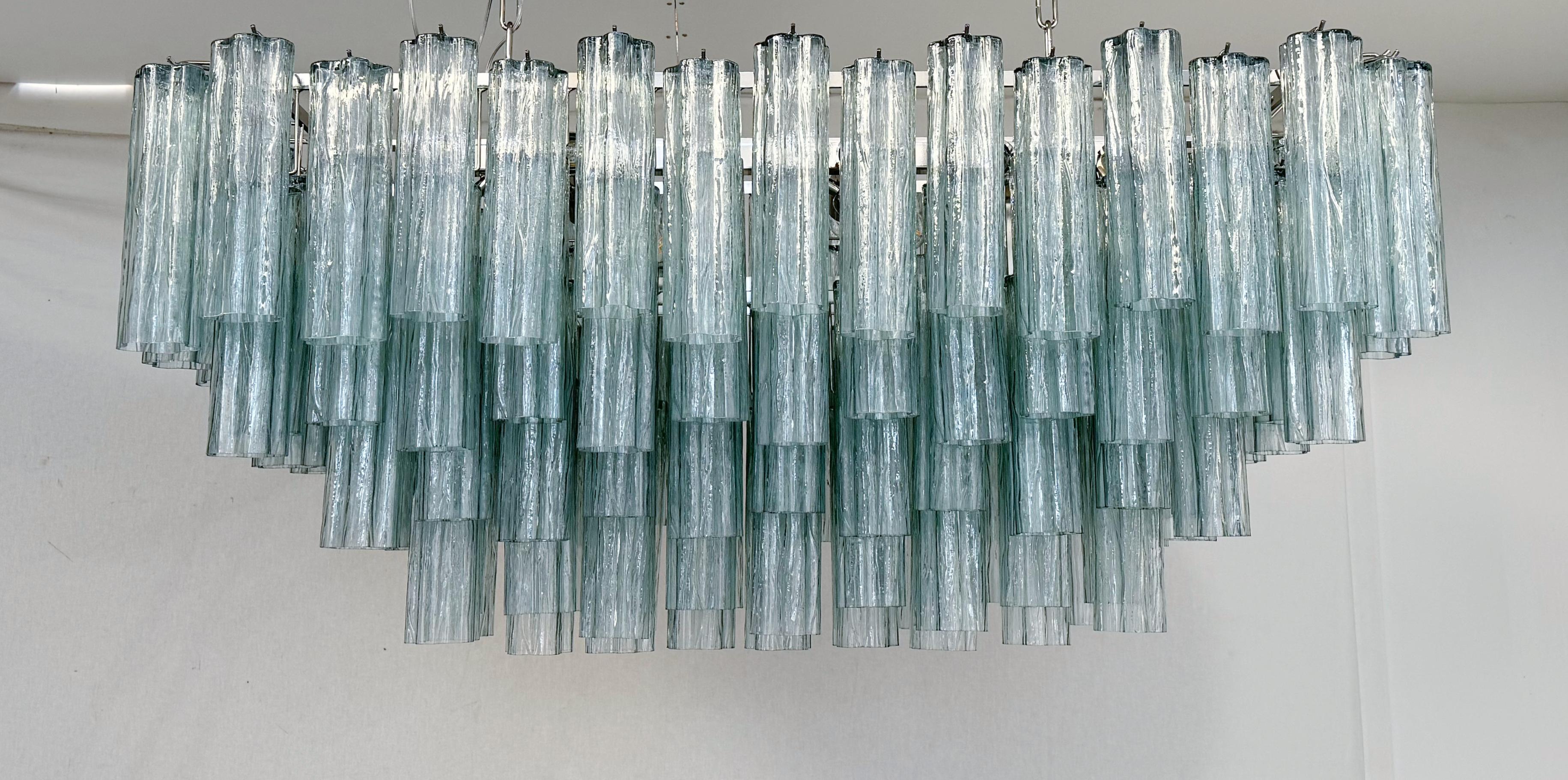 Italian rectangular chandelier shown in dusk green hand blown Murano Tronchi glasses arranged in cascading tiers, mounted on polished nickel finish metal frame hanging with two chains / Made in Italy
16 lights / E26 or E27 type / max 60W each