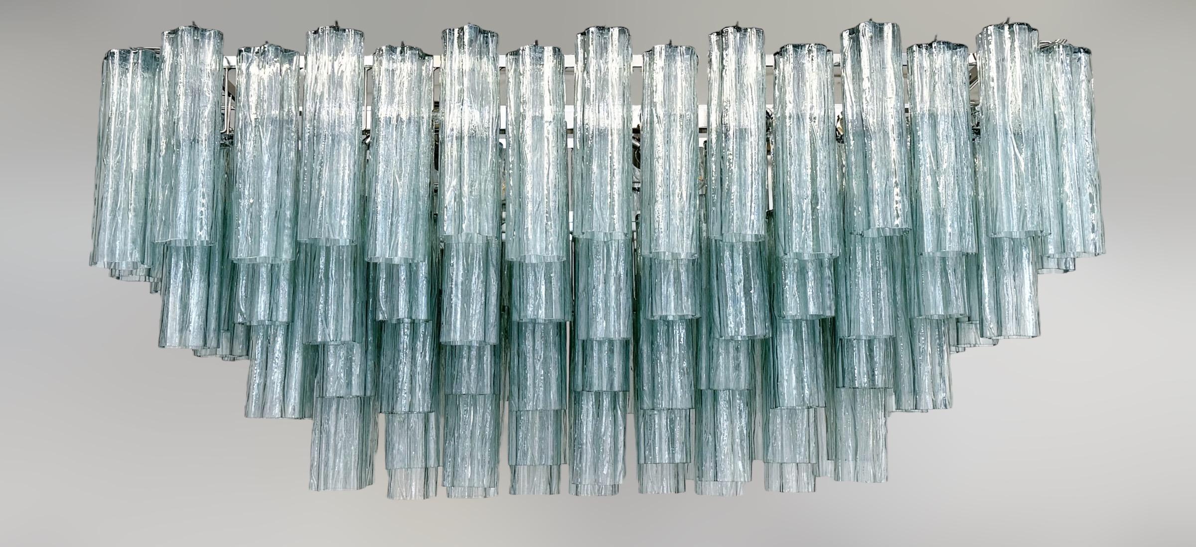 Italian rectangular chandelier shown in dusk green hand blown Murano Tronchi glasses arranged in cascading tiers, mounted on polished nickel finish metal frame hanging with two chains / Made in Italy
16 lights / E26 or E27 type / max 60W each