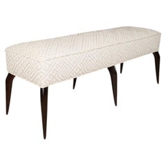 Rectangular upholstered bench with stylized ebonized wood legs.