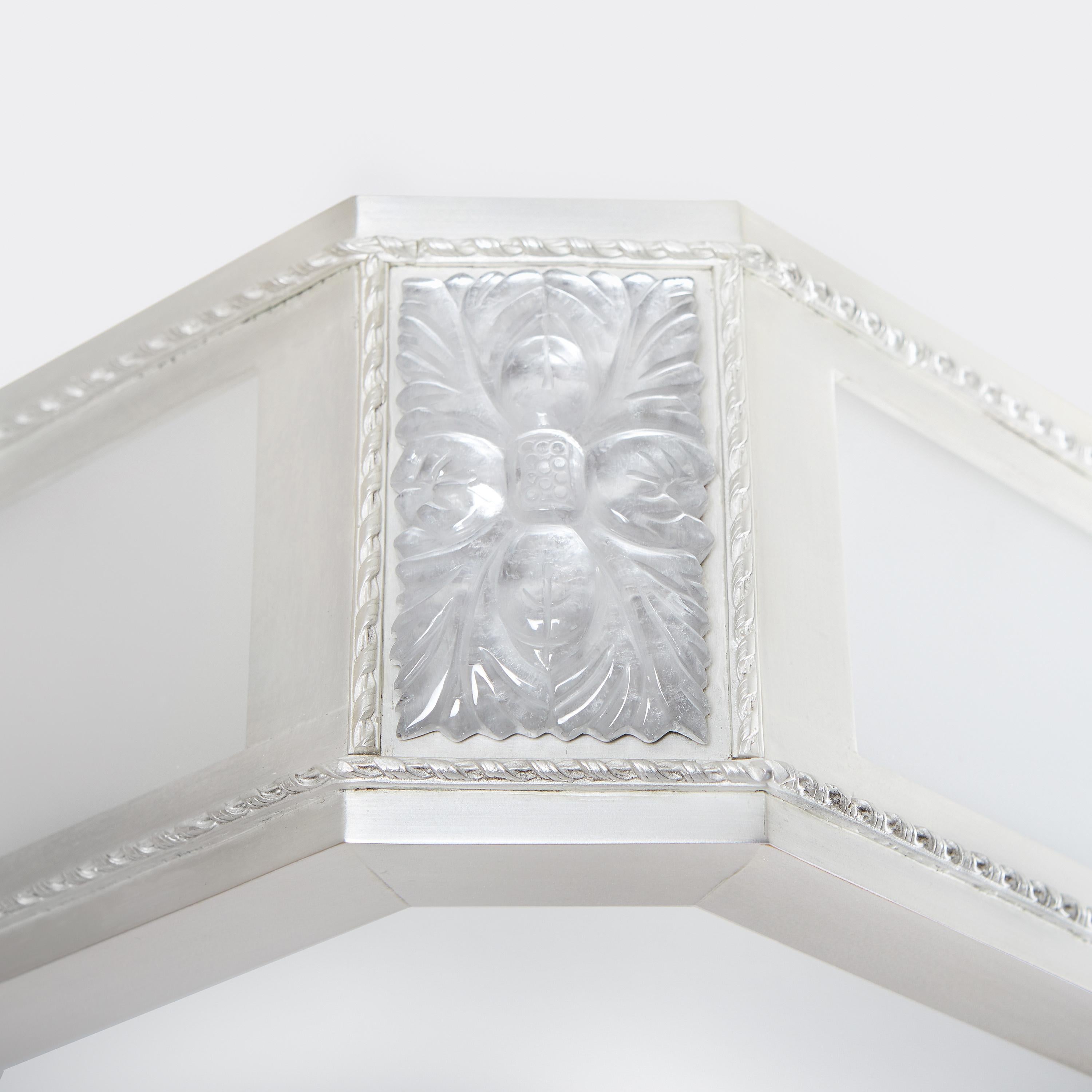 A rectangular pendant version of David Duncan's Victoire design. The frame having frosted low iron glass in four sections, separated by rectangular rock crystal rosettes on the corners. Suspended from rods and canopy, with frosted low iron glass