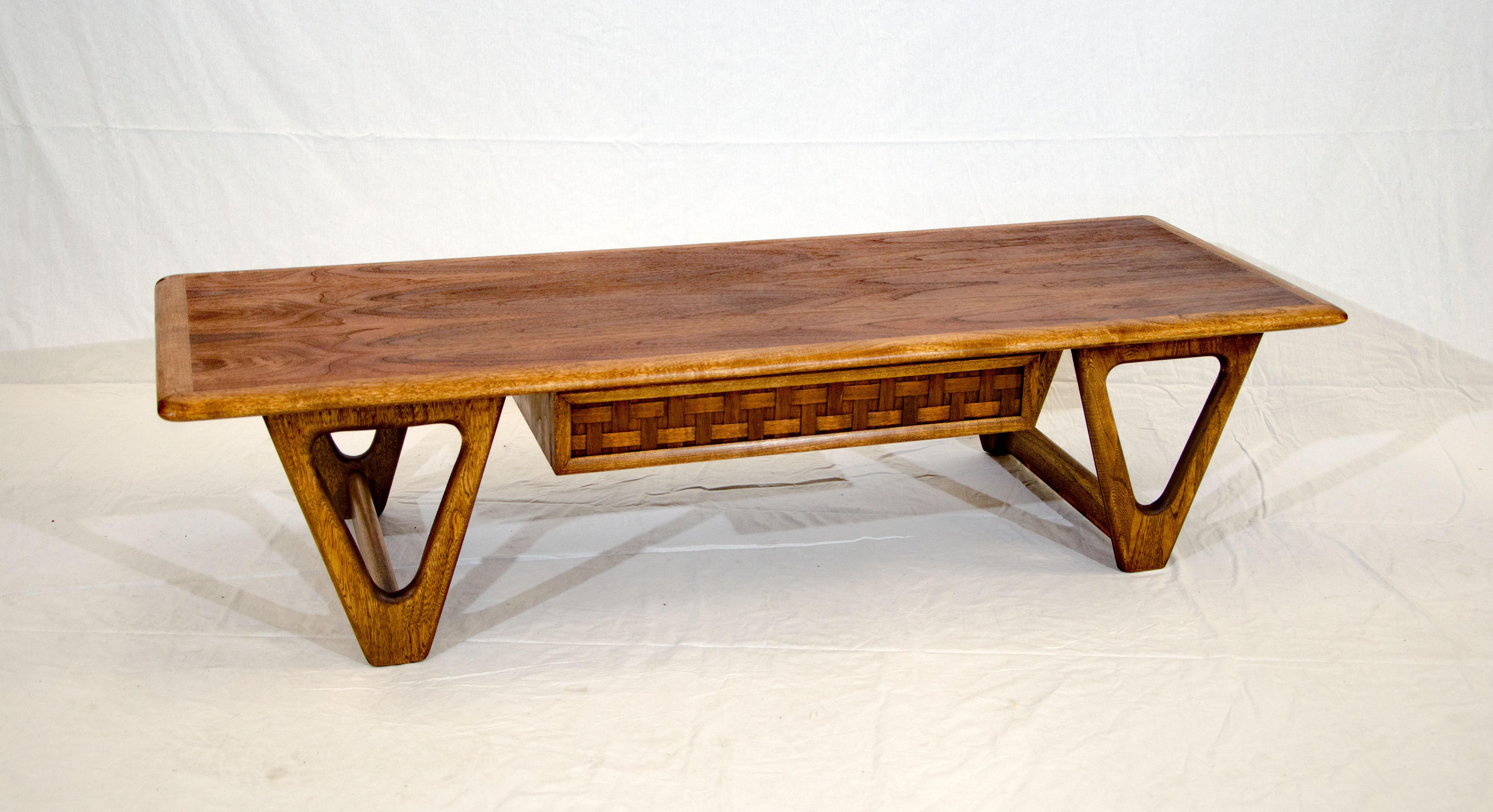 Midcentury rectangular walnut coffee table accented by an ash border and one drawer with a lattice Front Design. The base design consists of four 