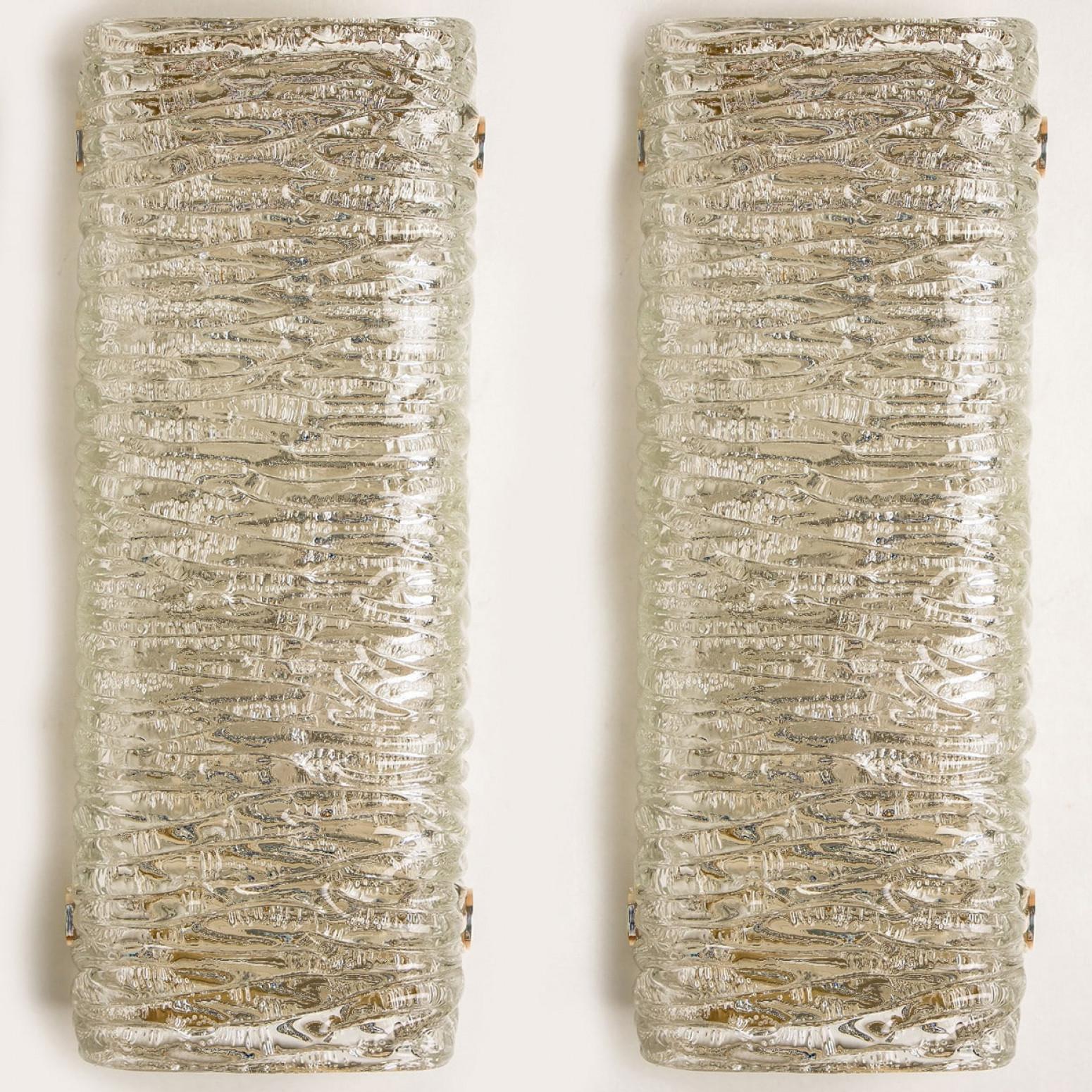 Luminaires rectangulaires en verre Wave de J.T. Kalmar, Vienne, Autriche, fabriqué vers 1960. Le verre présente une belle texture ondulée, qui donne un effet de lumière diffuse et un joli motif sur le plafond, les murs et le sol.
L'élégance de cette