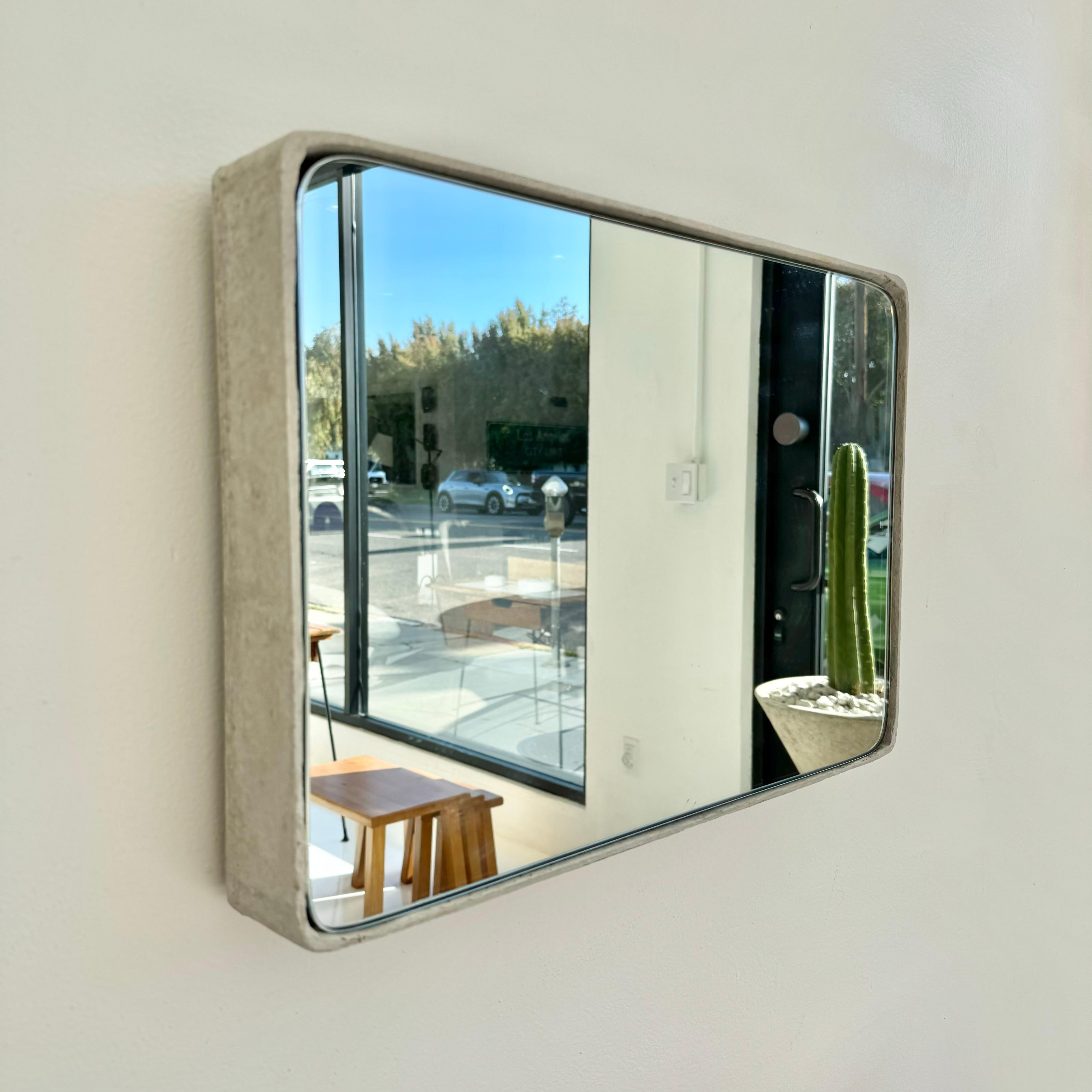 Gorgeous rectangular Willy Guhl concrete mirror. Concrete vessel originally produced at the Eternit factory in Switzerland in the 1960’s. Custom glass/mirror was professionally hand cut and added recently. Beautiful patina as expected with age