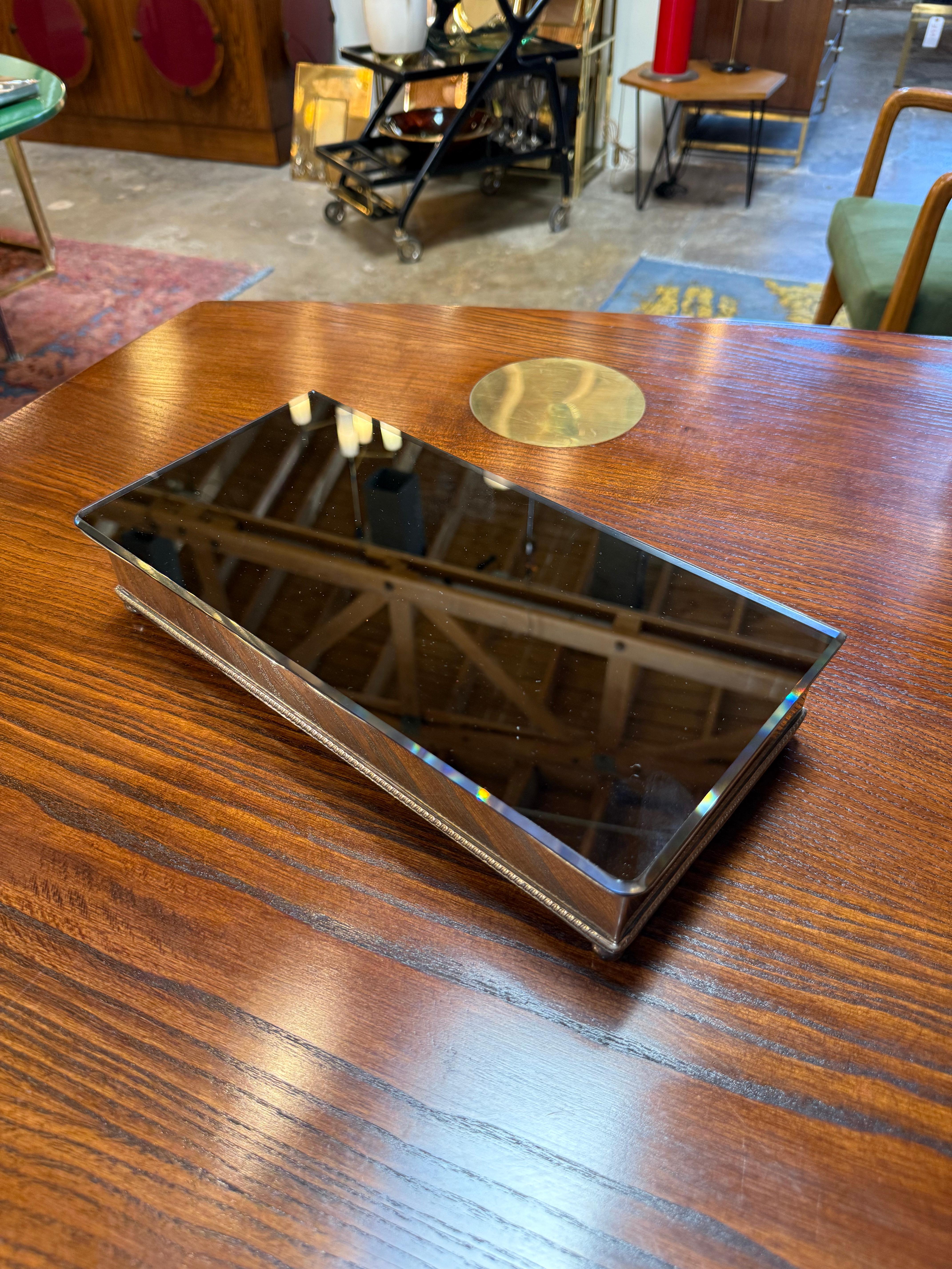 Raffinierte Aufbewahrungsbox aus der Mitte des Jahrhunderts mit einem rechteckigen Holzsockel, der mit einem Deckel aus Rauchglas versehen ist. Die Kombination aus warmer Holzmaserung und dunklem, reflektierendem Glas verleiht ihm ein elegantes,