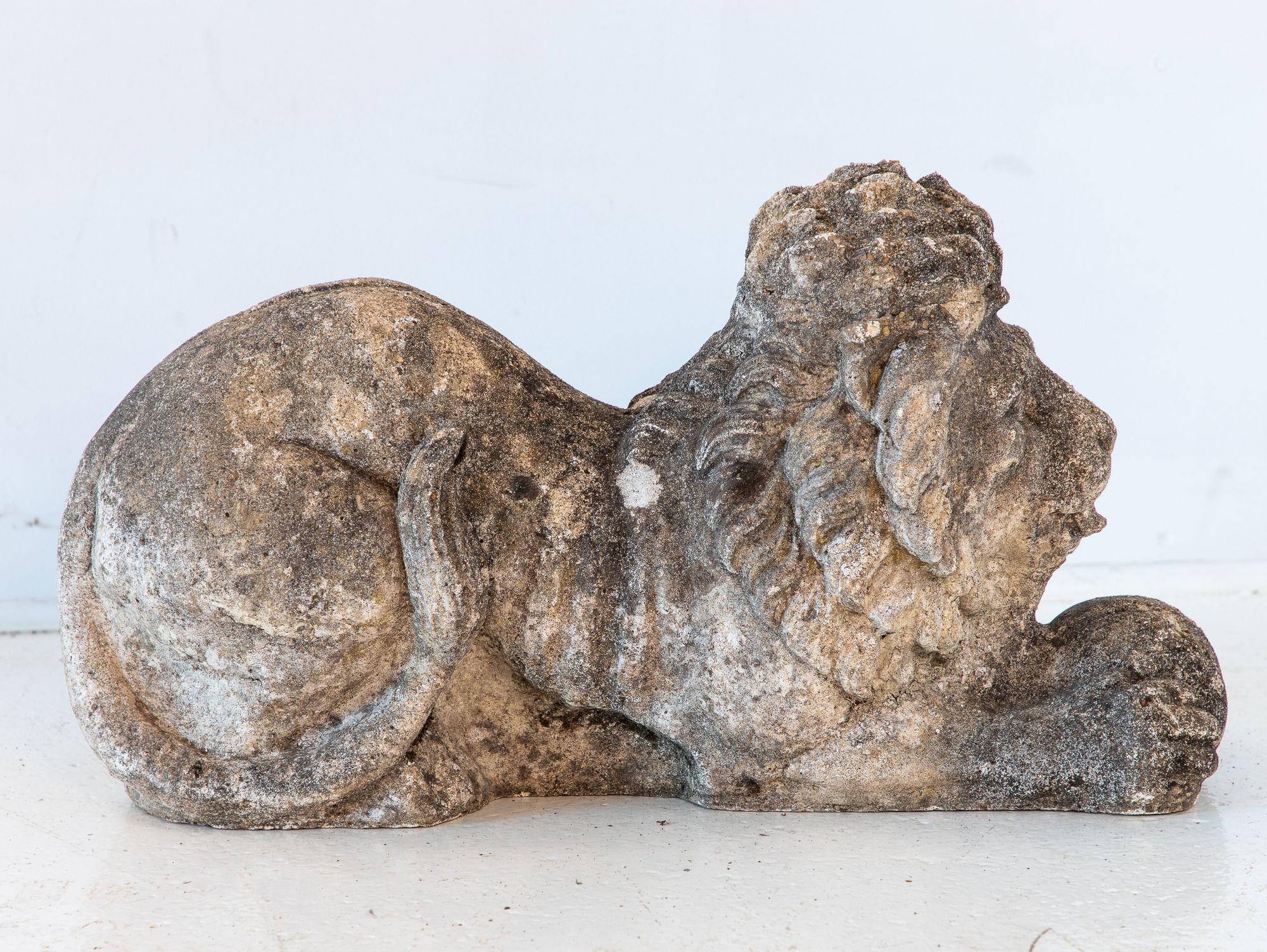 This French 20th-century concrete lion sculpture features a majestic yet serene figure, one paw resting gently on a sphere. Its weathered surface adds character, suggesting years of faithful presence in an outdoor setting. Ideal for garden paths,