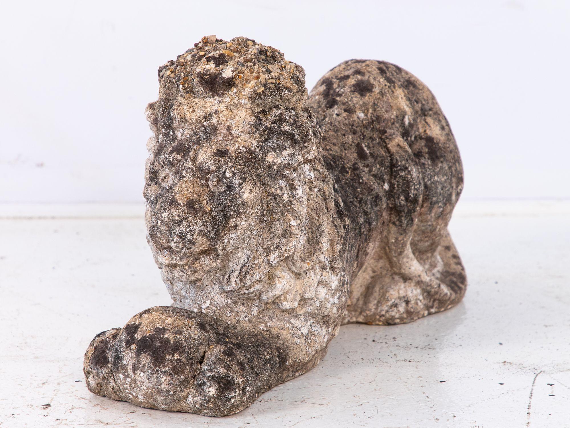 This French 20th-century concrete lion sculpture features a majestic yet serene figure, one paw resting gently on a sphere. Its weathered surface adds character, suggesting years of faithful presence in an outdoor setting. Ideal for garden paths,