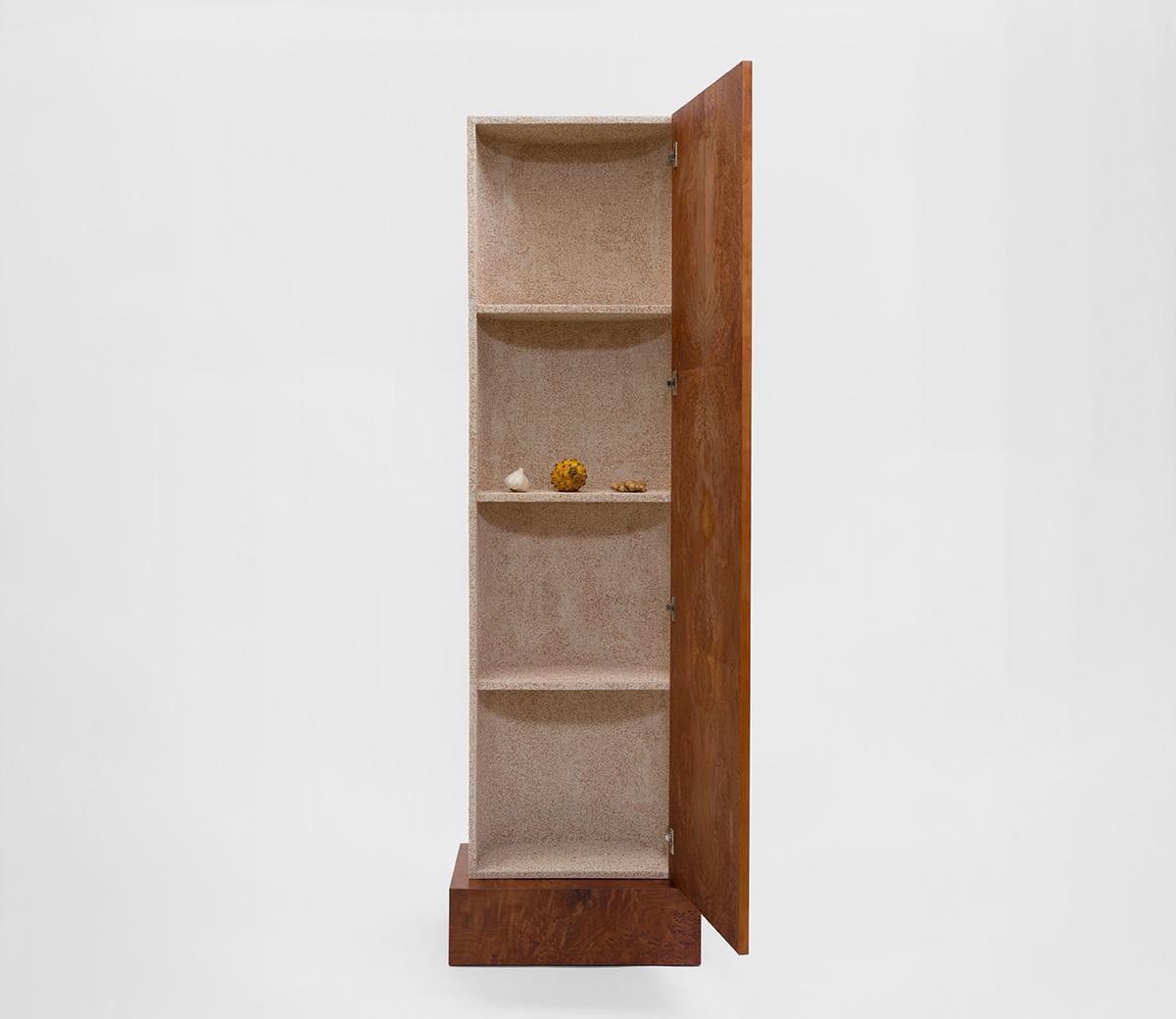 A thin monolith half moon atop a plinth of redwood burl veneer, the Special Damages cabinet has a curved back covered in — of all things — crushed eggshells. Rest Energy founder Caleb Engstrom looks at these materials as a duality: Burl wood – a