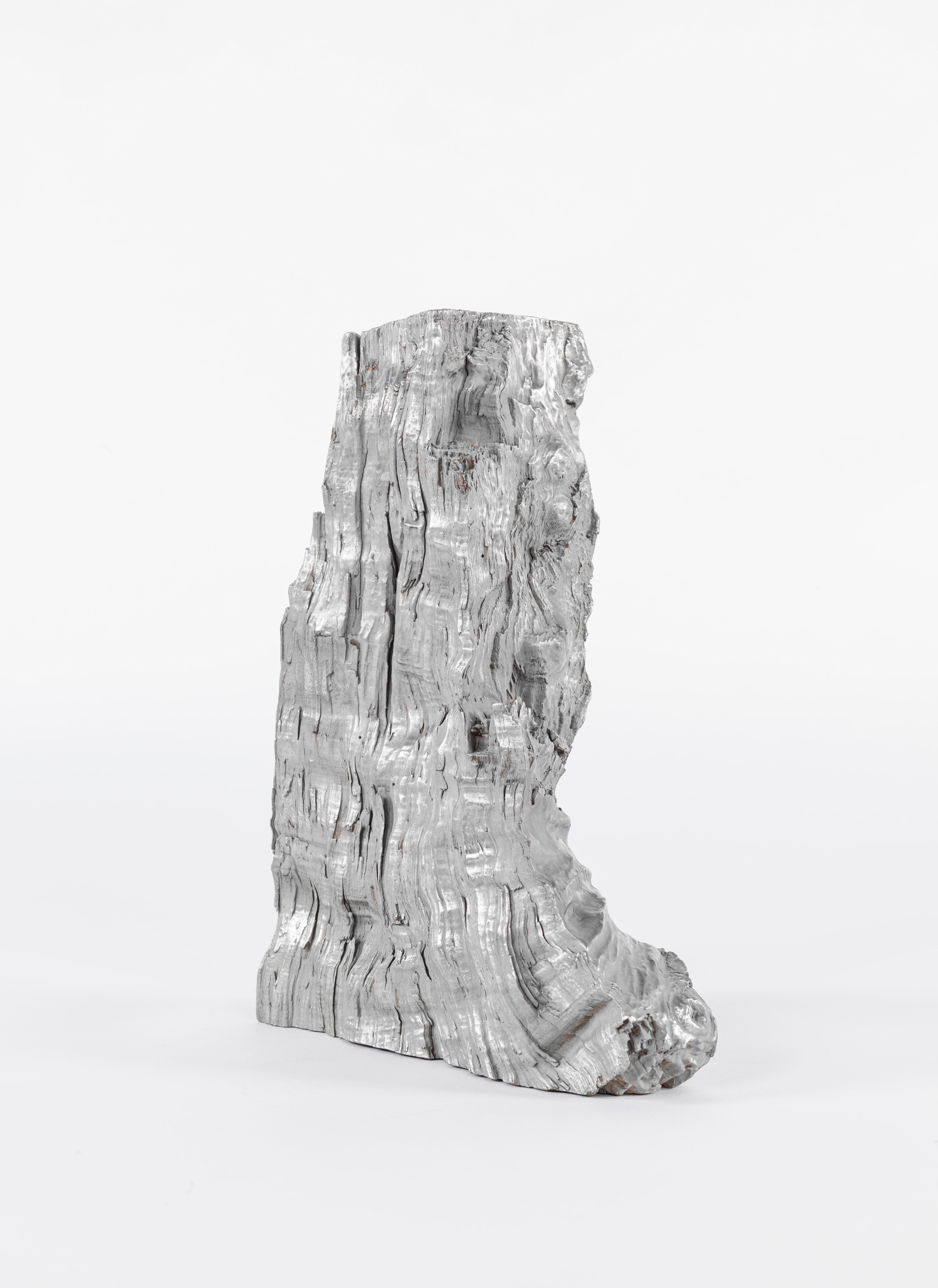 Discover our striking wood sculpture, part of an innovative series that reimagines discarded or burned wood with finesse. This unique piece showcases a cleaved piece of oak coated in polished tin. Meticulous craftsmanship and fine finishing