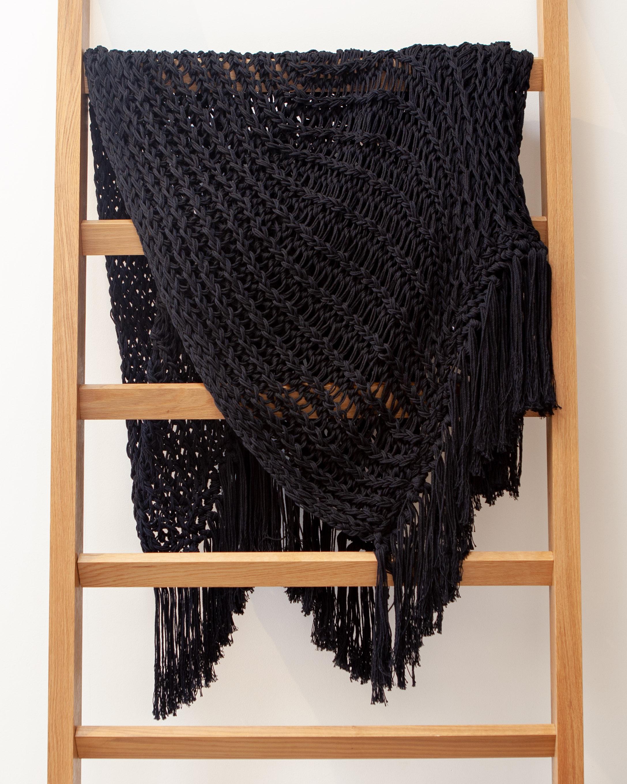 This black artisan throw is handmade from recycled cotton, a natural material that gives it a high-end look and feel. With an open weave design, it adds a luxurious element to home decor. This designer piece in classic black is perfect to bring a