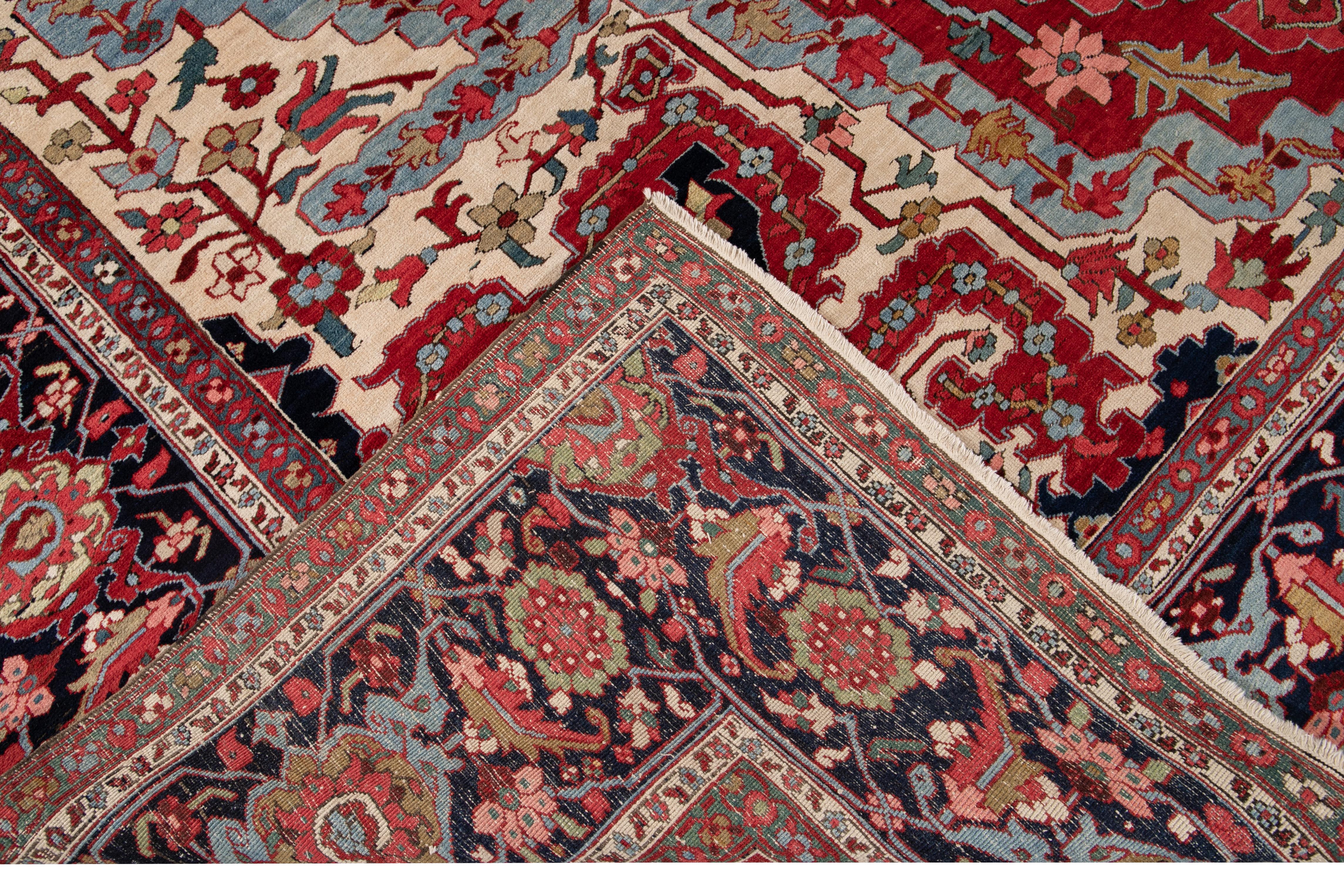 Beautiful antique oversize Serapi hand knotted wool rug with a red field. This Serapi rug has a navy-blue frame and multi-color accents with a center medallion floral design,

circa 1890.

This rug measures 12' x 20'.