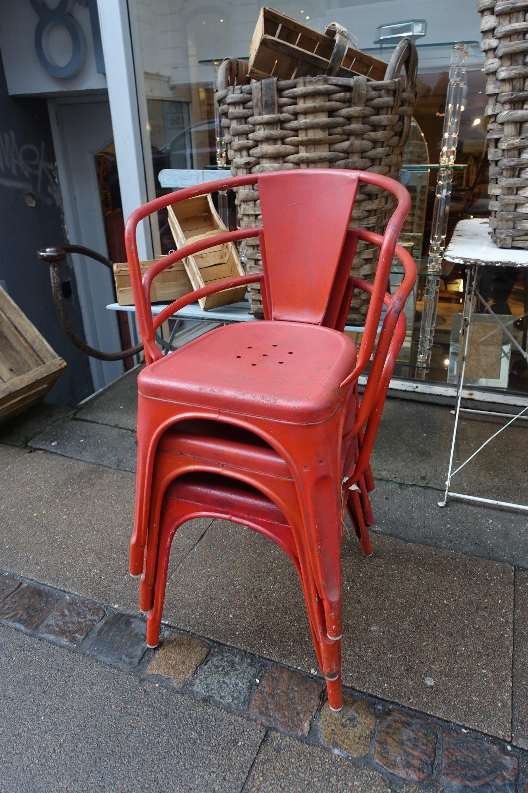 Fabuleuse chaise Tolix vintage en métal A56 avec accoudoir, conçue par Jean Pauchard. Une extension de la variété de chaise (qui n'avait pas d'accoudoirs) et produite depuis 1956. Apparaît en fer traité et poli, magnifiquement peint en rouge.