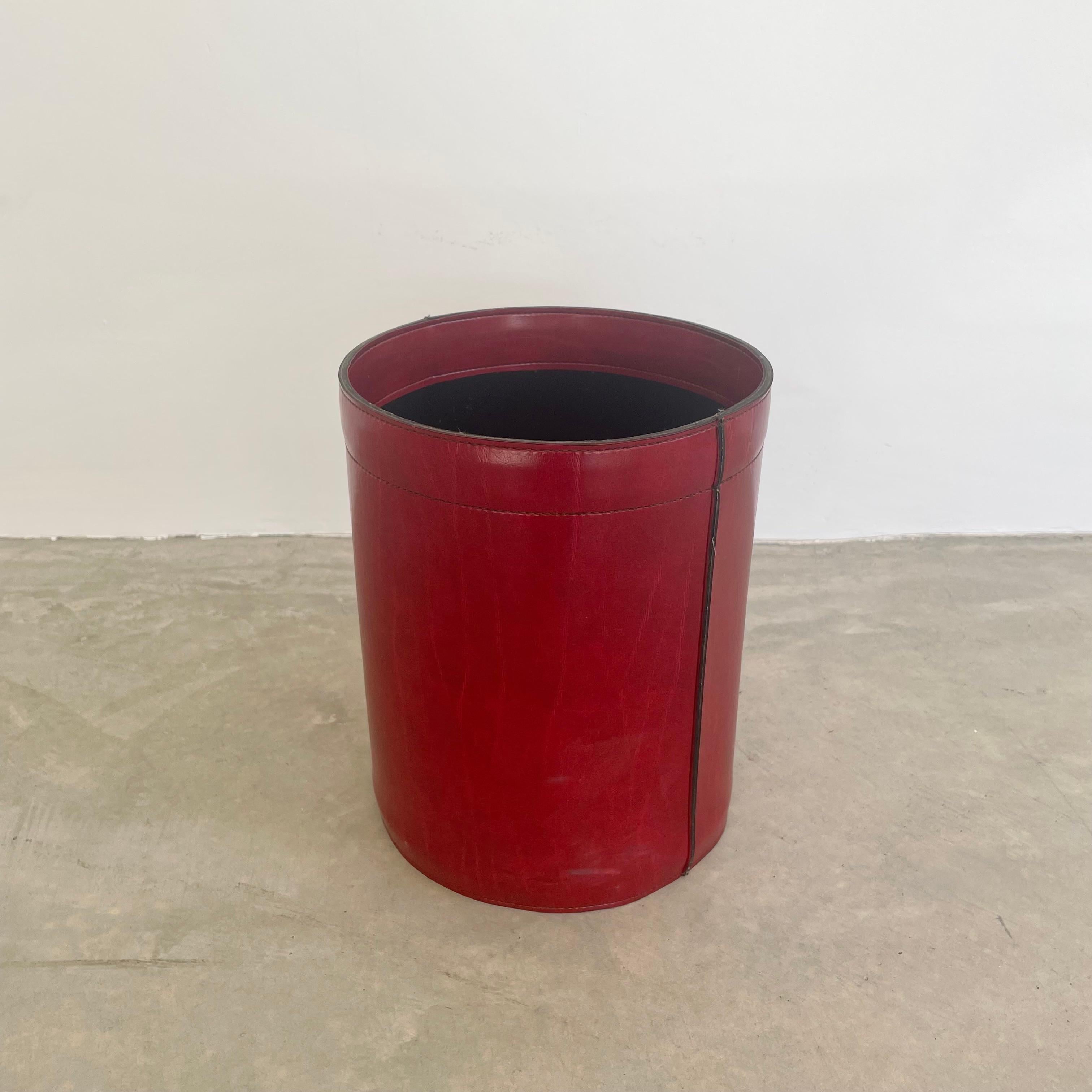 Chic red saddle leather waste bin in the style of Jacques Adnet. Circa 1960s. Handmade and hand-sewn from bordeaux red leather with a black leather interior. In good condition with nice patina on the leather. Great color and age. Staining and age as