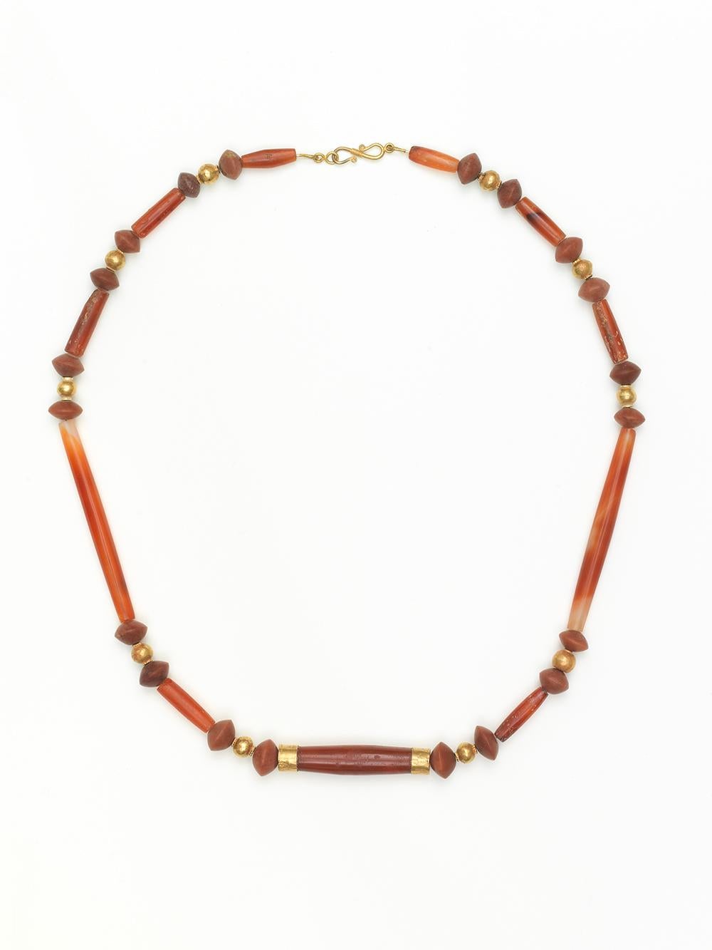 This striking necklace is made of expertly carved tubular carnelian and red agate stone. Most likely from the Hellenist period or just after, jewellery at this time was worn by both men and women. 

Much of the jewellery in Ancient Greece, the