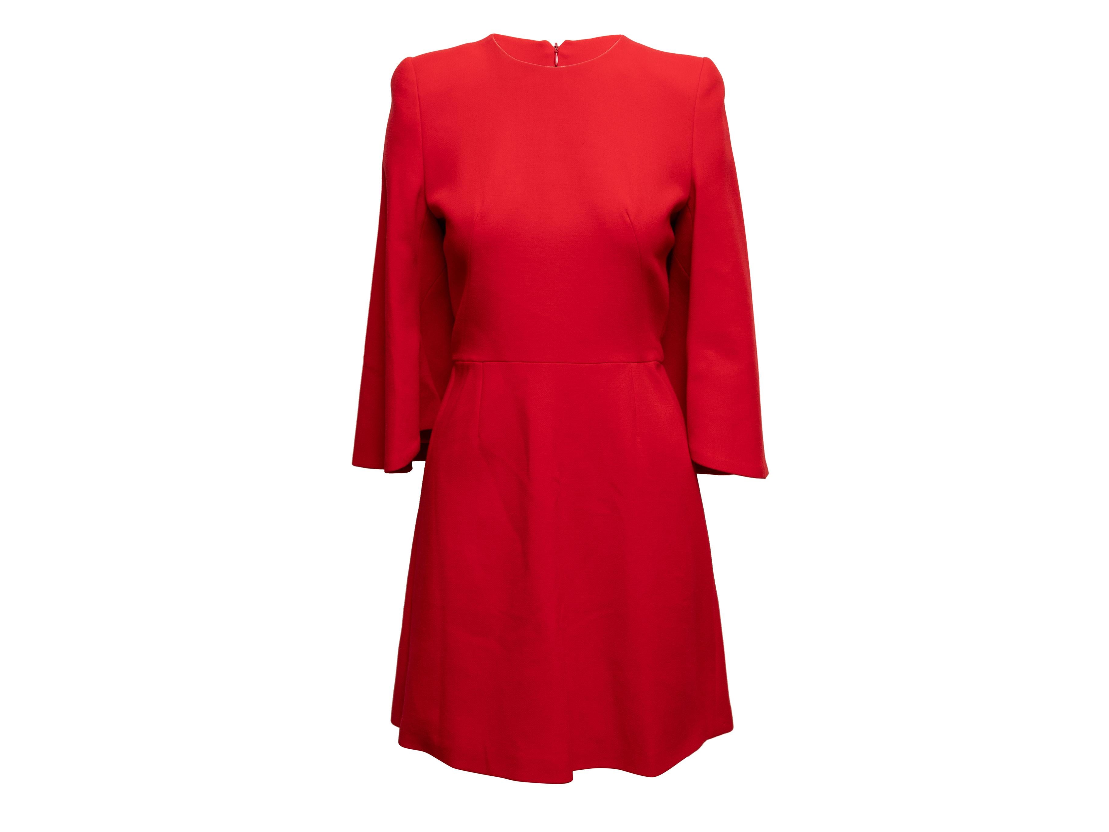 Red A-line cape dress by Alexander McQueen. Crew neck. Long cape sleeves. Zip closure at center back. 28