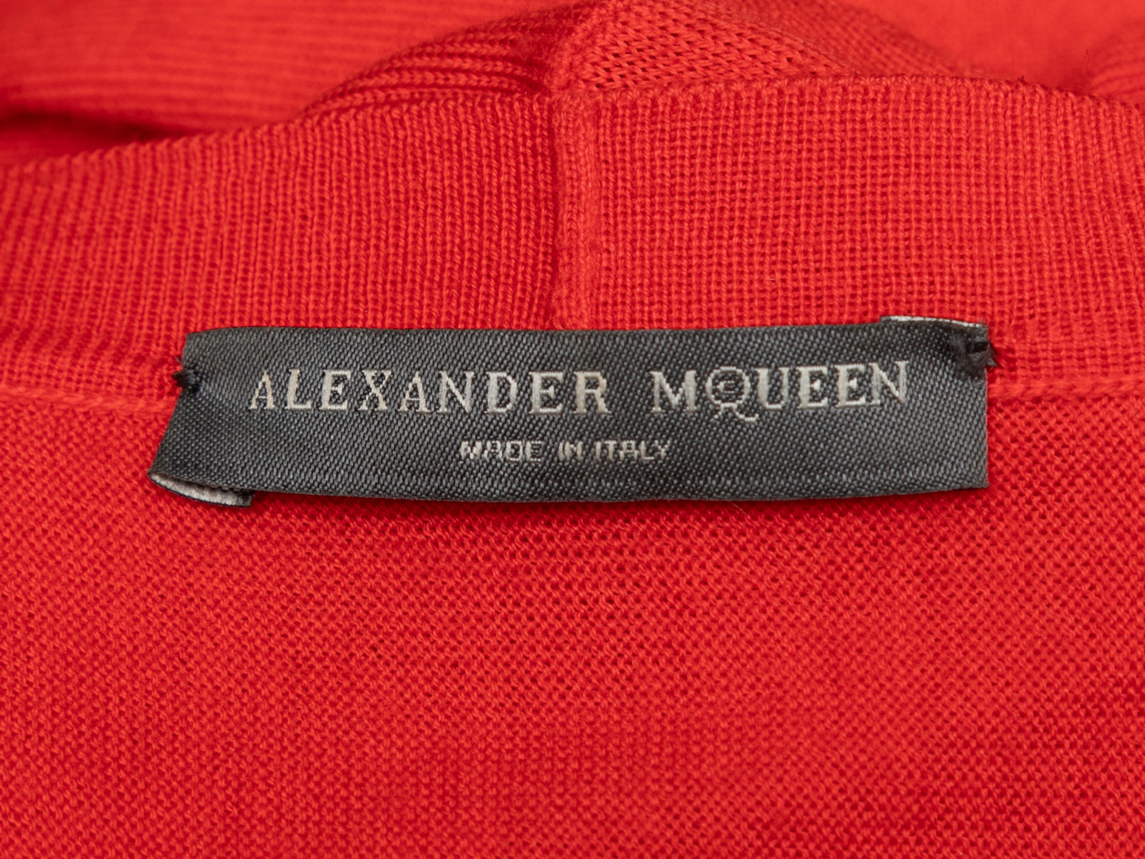 Red wool peplum cardigan by Alexander McQueen. V-neck. Button closures at center front. 35