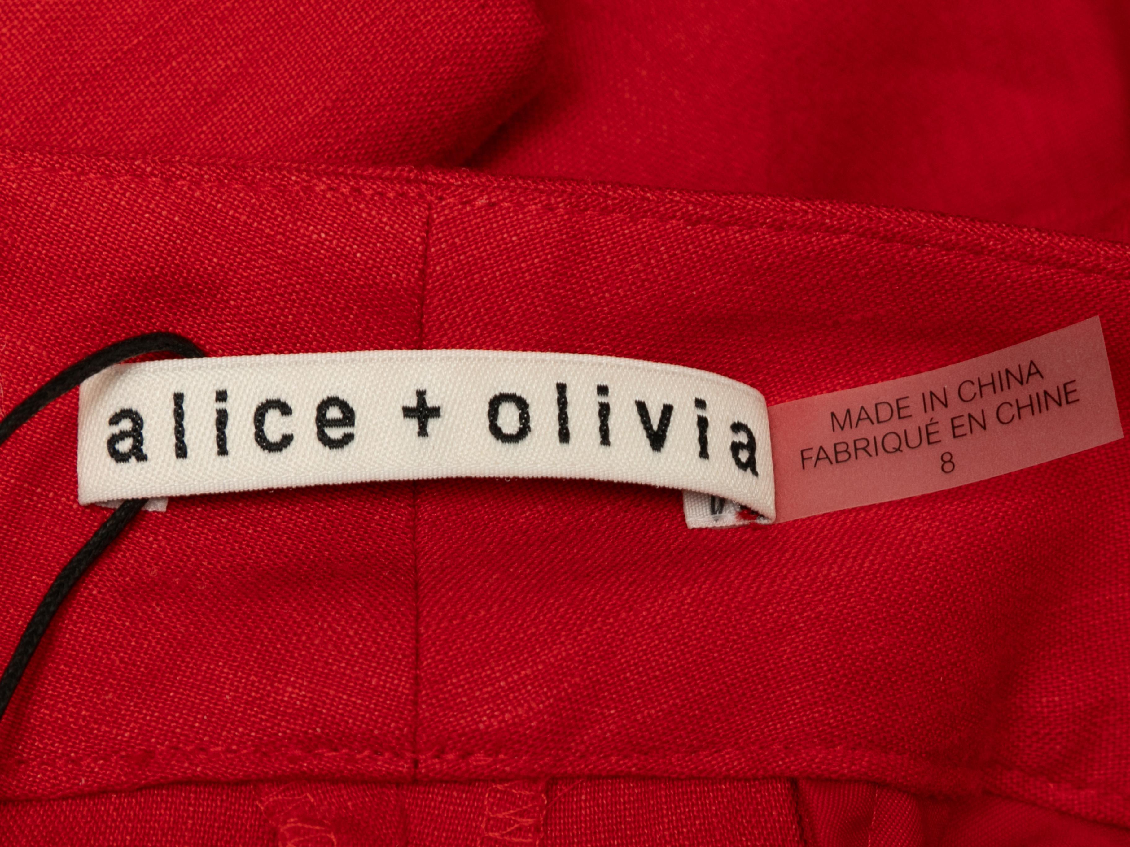 Red linen cargo pants by Alice + Olivia. Eight pockets. Zip and button closures at front. 32