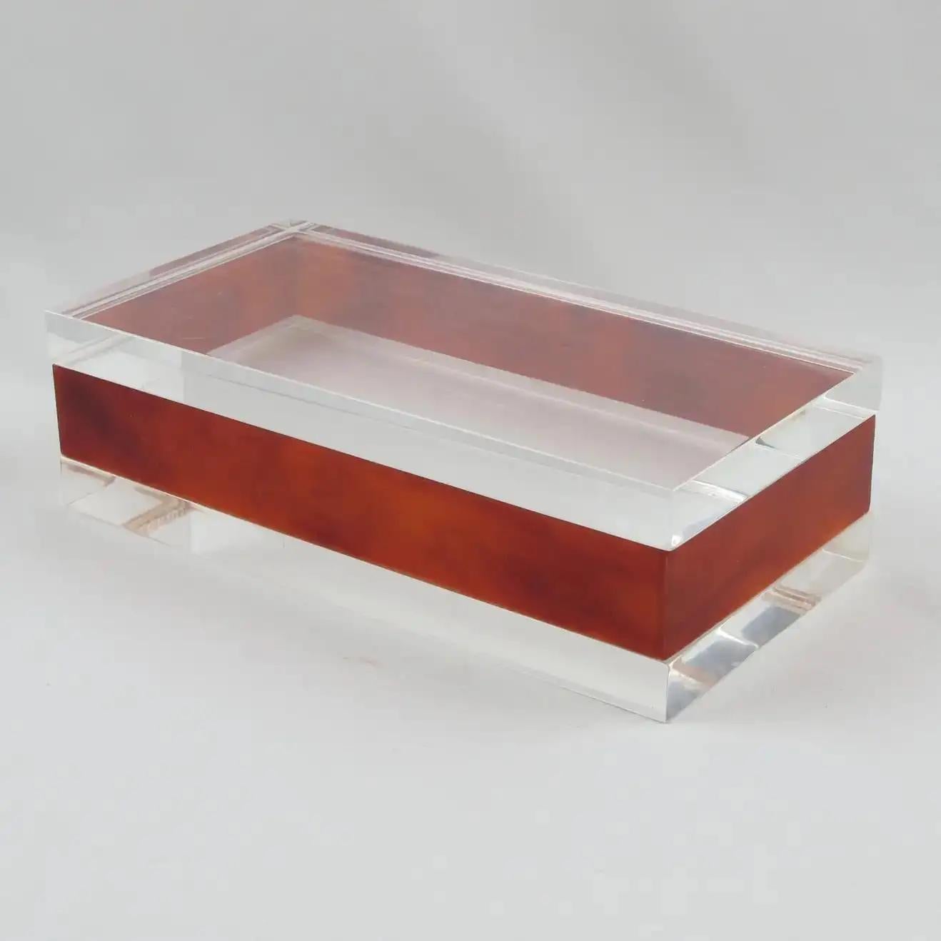 This stunning modernist Lucite, acrylic lidded box was crafted in France in the 1970s. The piece boasts transparent and red tea amber marble colors with a geometric rectangular shape and contrasting design. There is no visible maker's