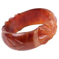 Bracelet jonc en bakélite ambrée avec sculpture florale