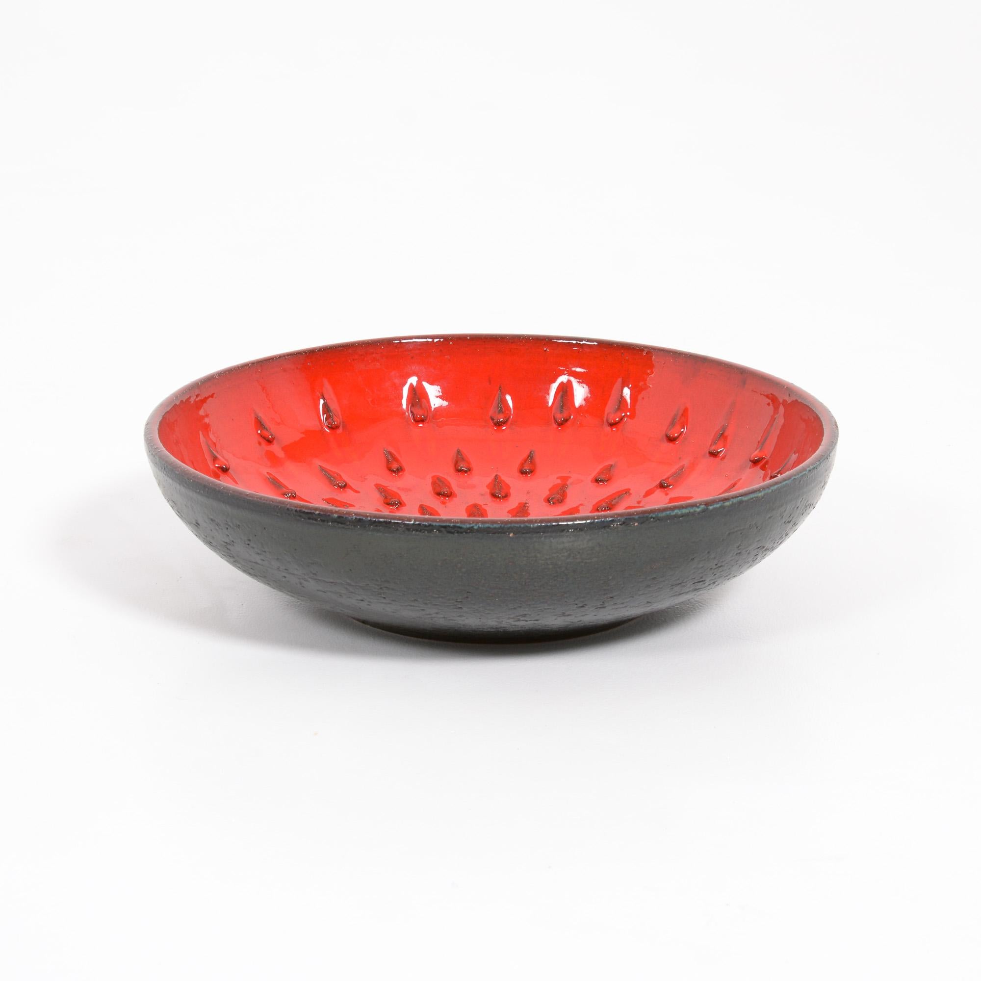 This beautiful red bowl was created by Rogier Vandeweghe in his workshop Amphora. It can be dated in the 1960s.
The inside is decorated and finished with the amazing red glaze. The outside of the bowl has a rough texture, black glazed.
The bowl is