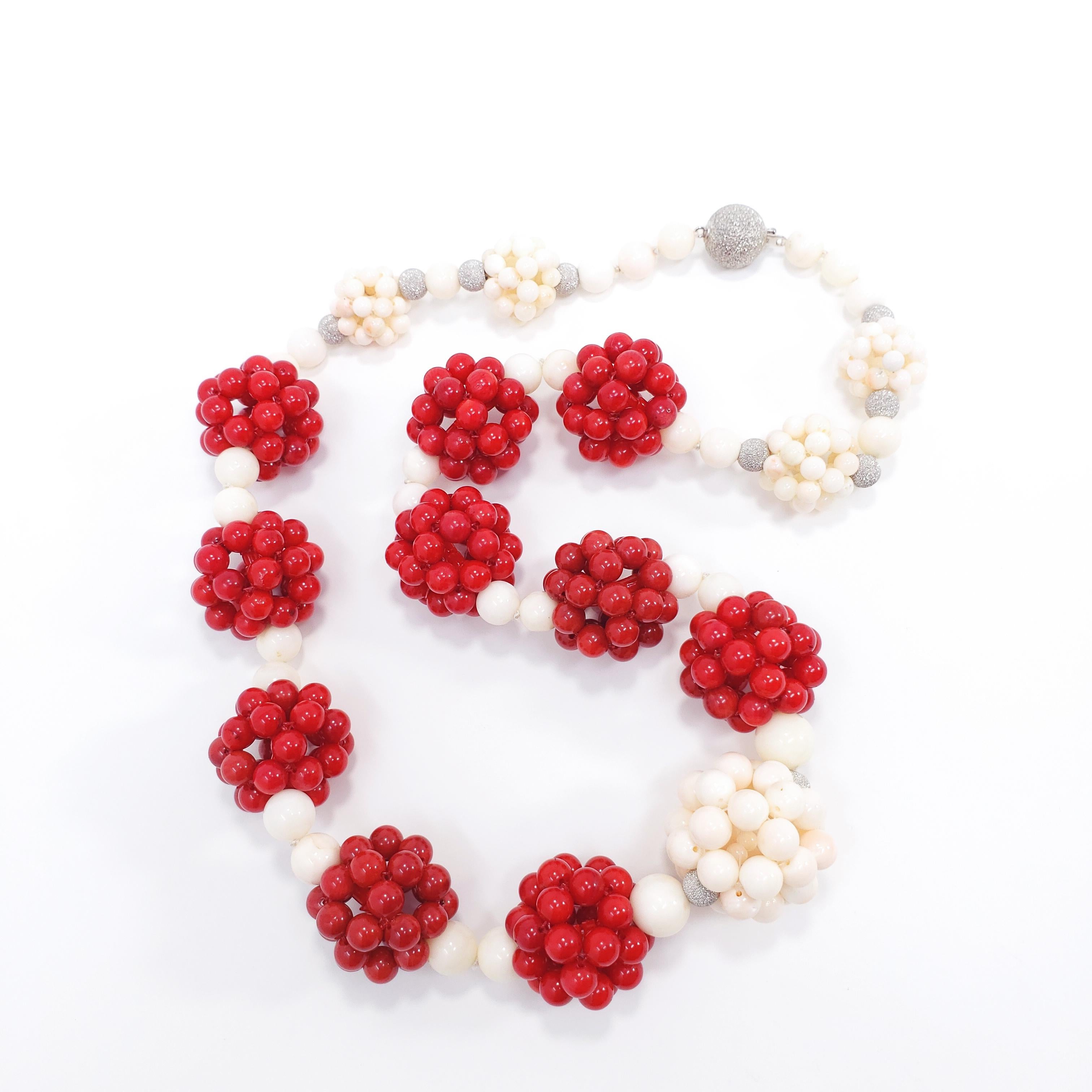 An exquisite red and white coral necklace! Features graduated genuine red coral and angel skin coral beads, accented with ornate coral clusters and 14K white gold findings. Fastened with a 14K white gold diamond dust ball clasp. Fit for