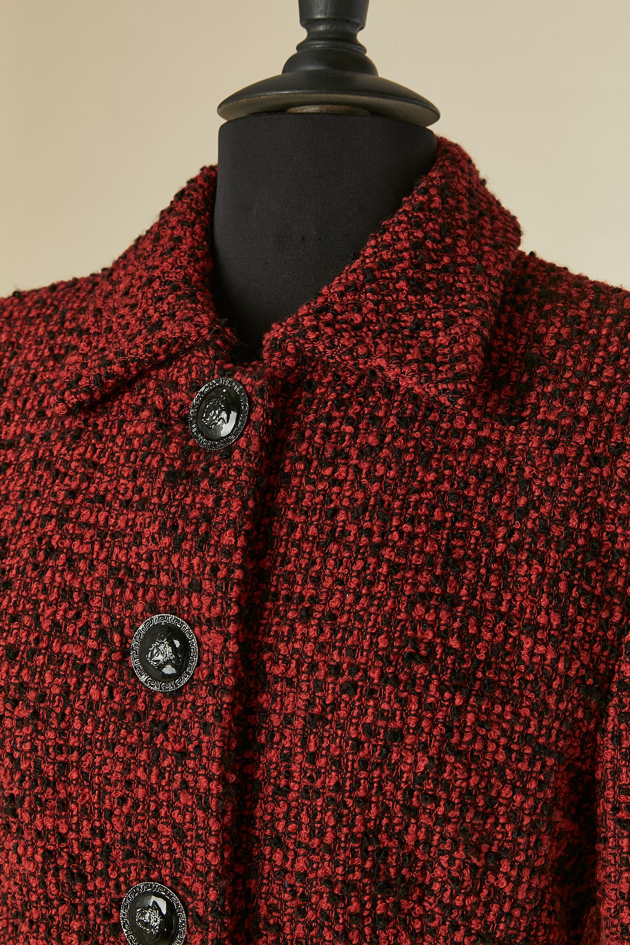 Abito con gonna in tweed rosso e nero. Composizione del tessuto principale: 94% lana, 6% nylon. Fodera in rayon.
Spallaccio. Chiusura con bottone e asola con marchio sul centro davanti e sulla patta della tasca. Stesso bottone sui polsini ma senza
