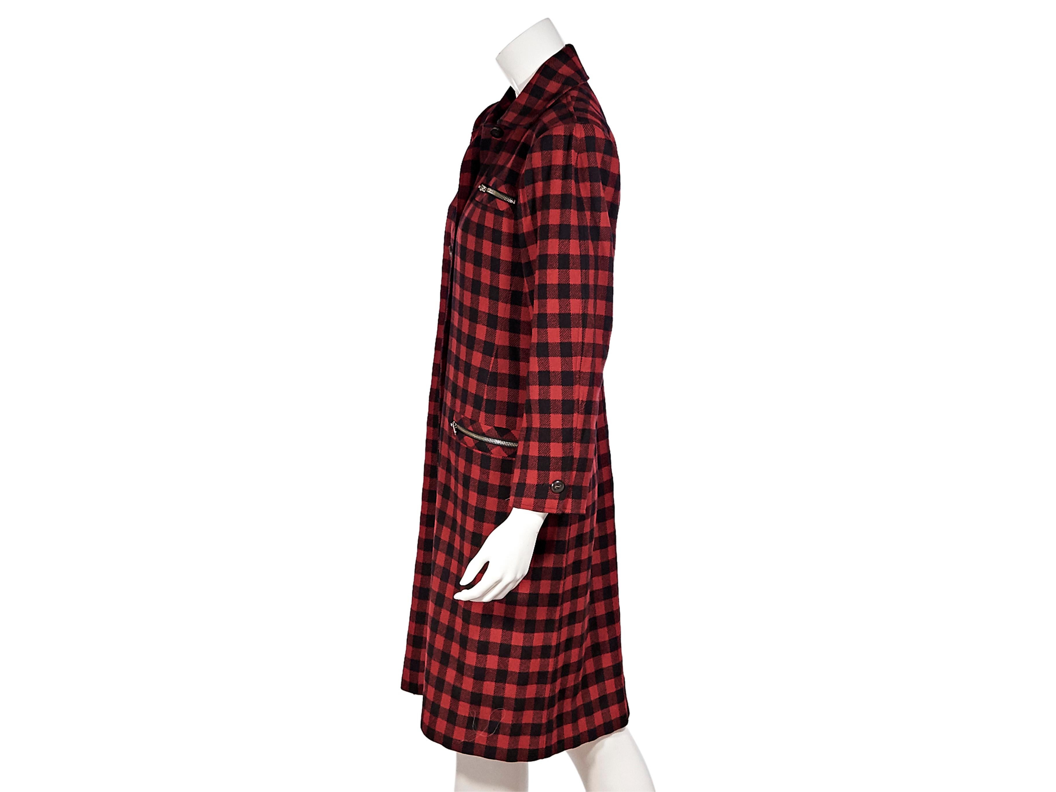 Product details:  Vintage red and black checkered wool jacket by Yves Saint Laurent Variation. Pointed collar. Long sleeves. Two zip pockets at sides. Single zip pocket at chest. Button-front closures. Silver-tone hardware. Knee-length. Style yours