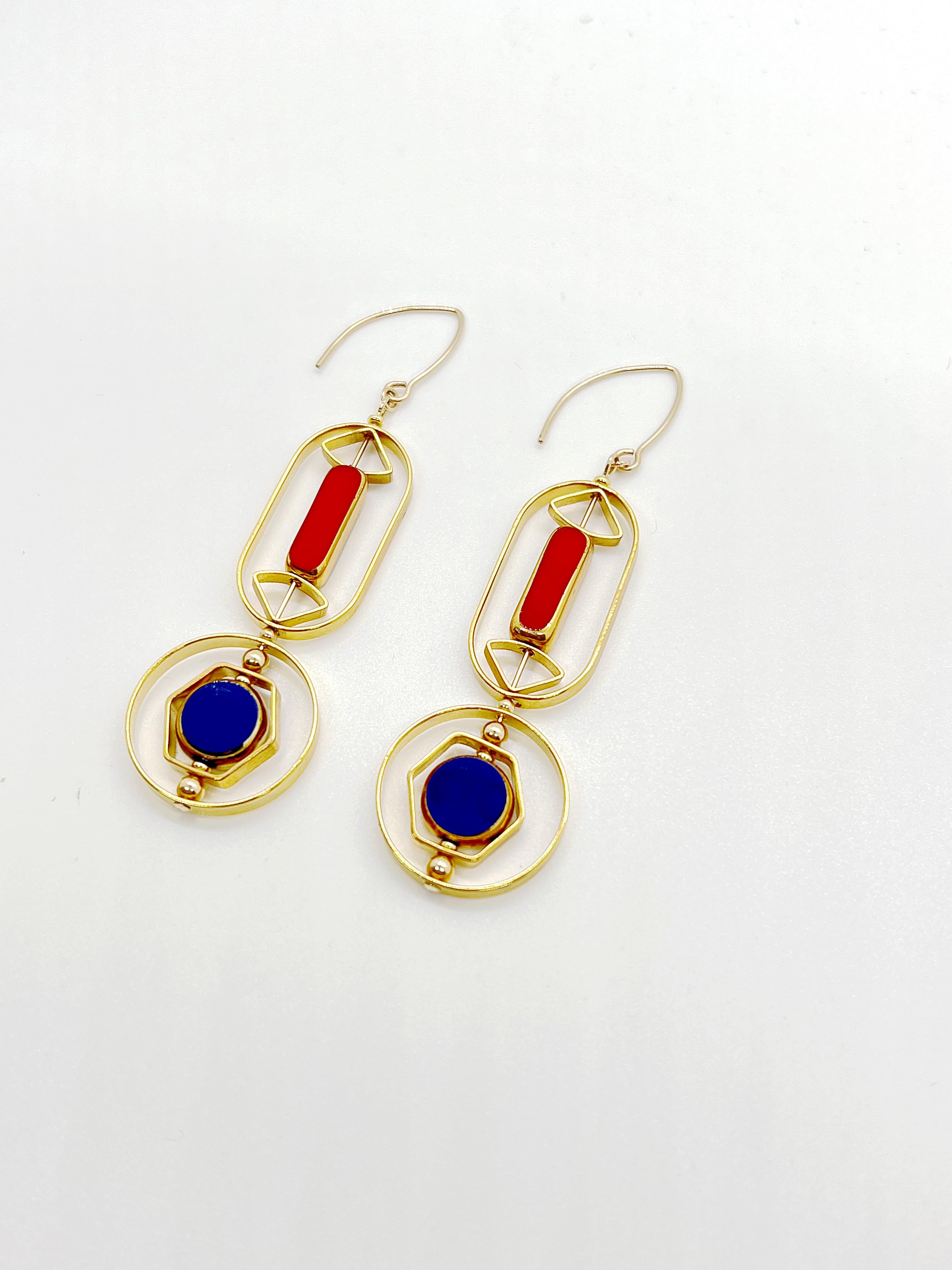 The earrings are light weight and are made to rotate and reposition with movement.

The earrings consist of a red long rectangle and blue circle shaped beads. They are new old stock vintage German glass beads that are framed with 24K gold. The beads