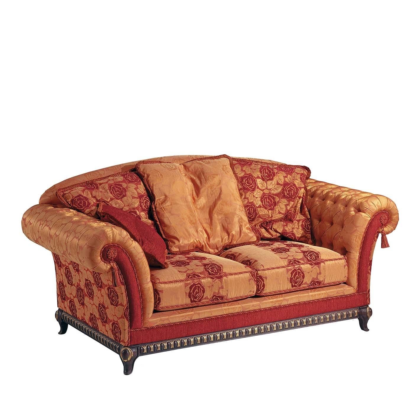 Fabric two-seat sofa with wooden base and Queen Anne style legs. Red floral pattern in contrast with the orange base emerge both on the seats and on the external sides. The CapitonnÃ¨-style padded inner part completes this elegant piece of furniture.