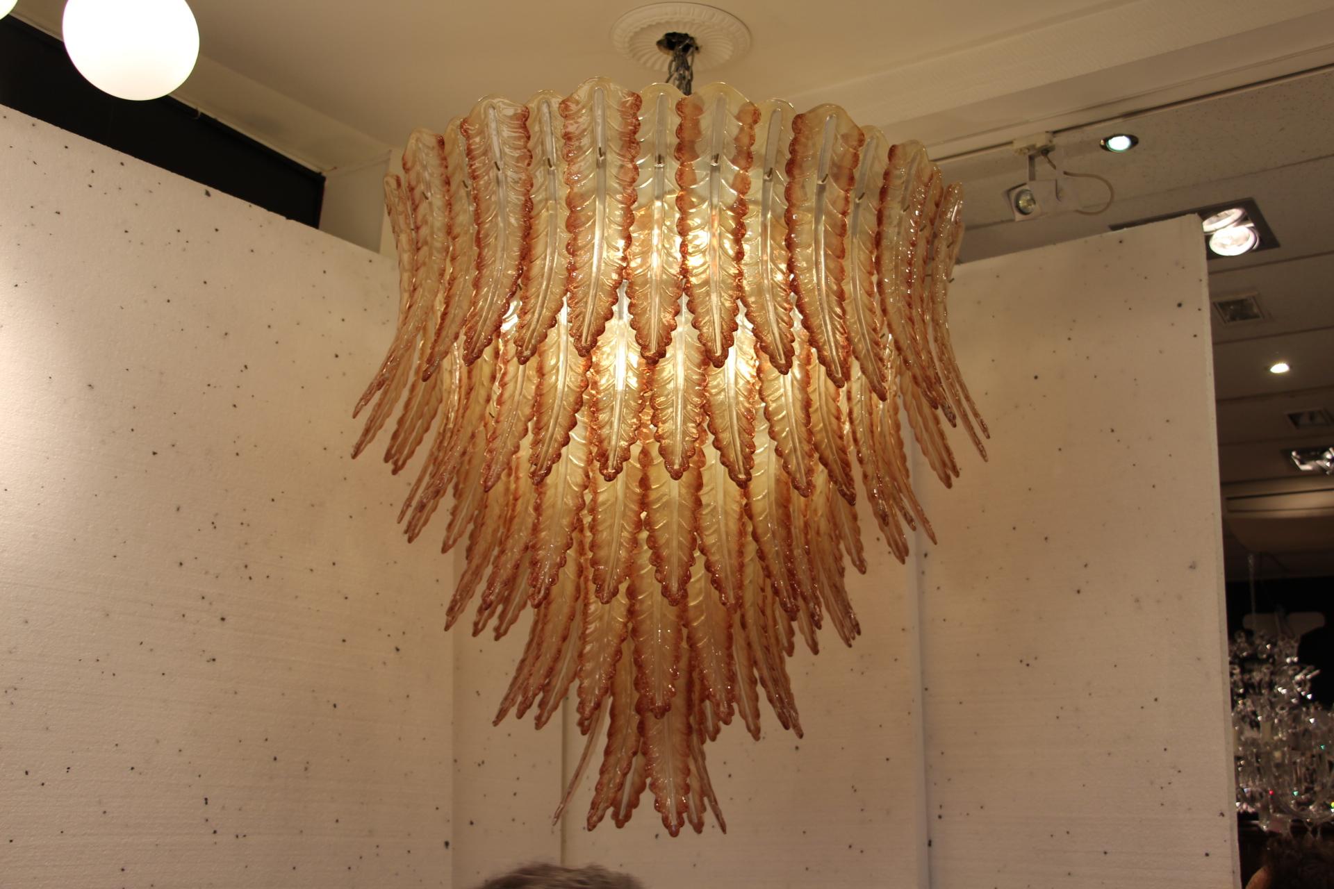 This spectacular chandelier features beautiful Murano glass palmettes in champagne beige color with coral red color hedges. Its colors are very warm and pleasant.It features five tears of glass leaves. Each glass leaf has been individually made in