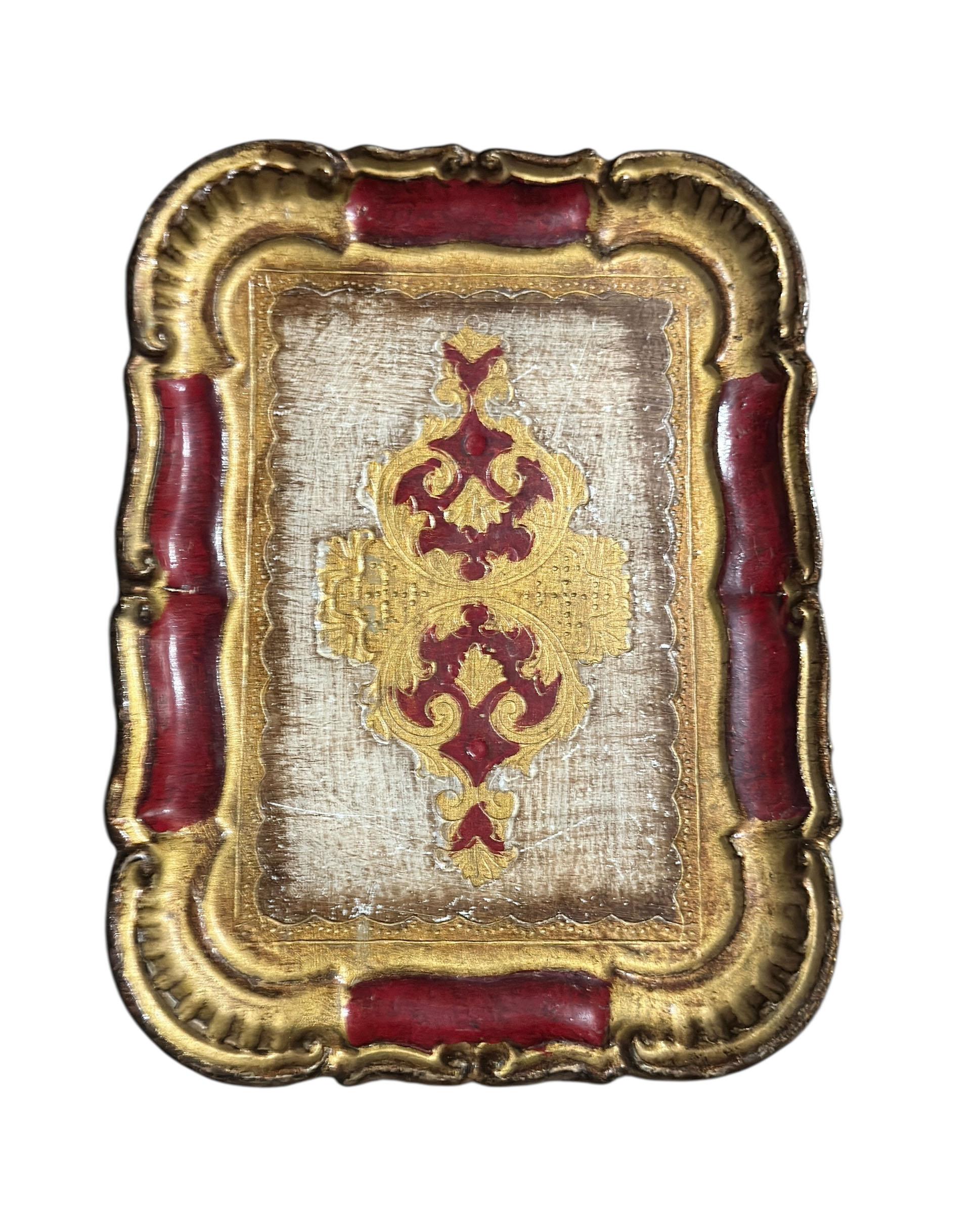 Un magnifique plateau italien Florentine peint à la main dans de riches tons rouges et or, signé Florence, Italie. 

Cette pièce met en valeur la beauté intemporelle de l'artisanat italien en matière de dorure, avec un design orné en relief et une