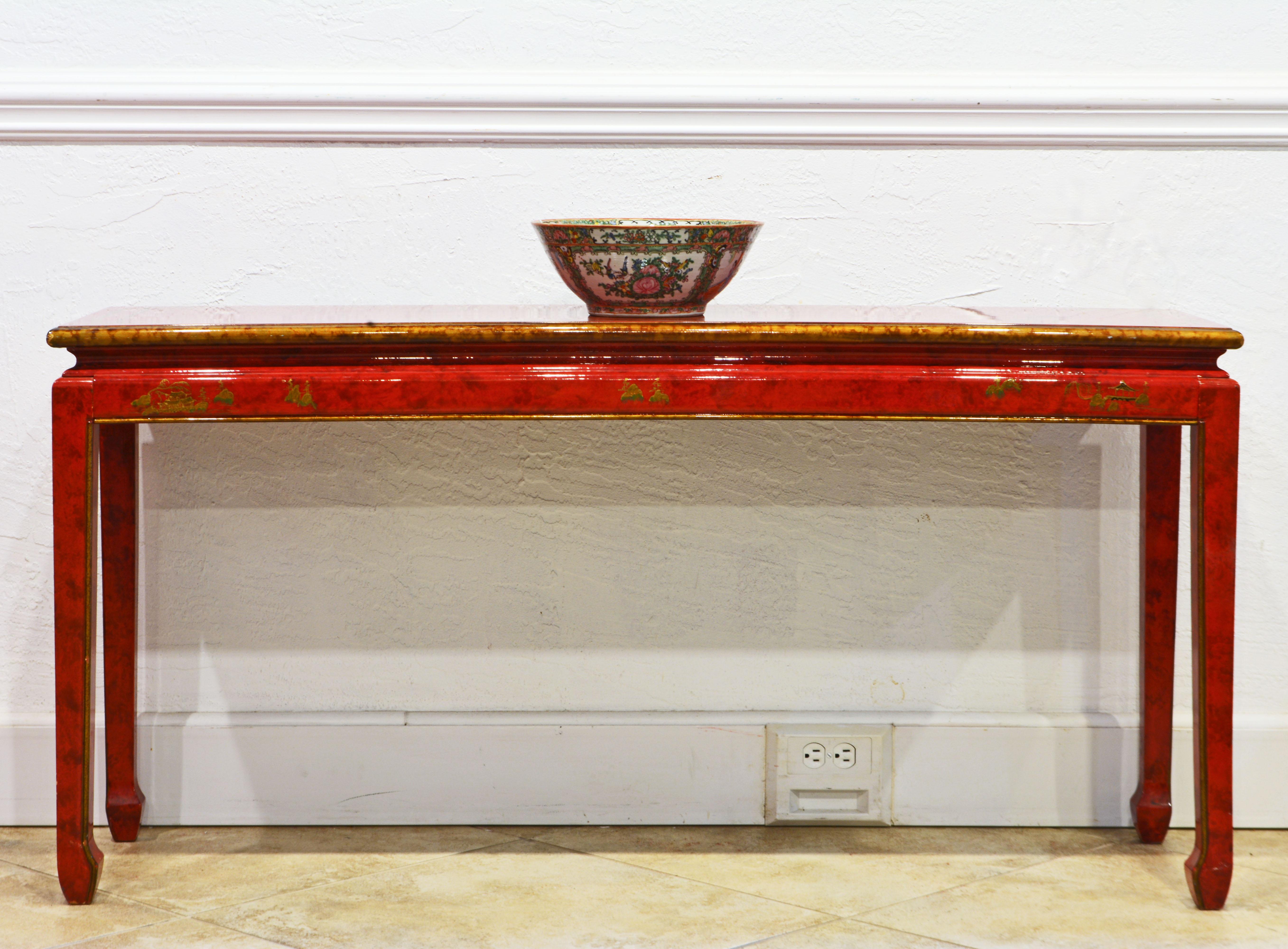This elegant mid century lacquered chinoiserie Ming style console table features a waisted top decorated with gold finish bands and edge above the frame with chinoiserie gilt motifs and four Ming style legs accented by gold finished edges. The table