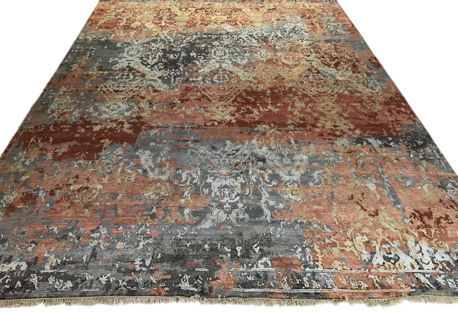 Fire and stone come together in this popular transitional Indian wool area rug. Shades of red and gold generate heat against a cool slate gray background. The high low style adds texture and creates a flame that begs to be touched!