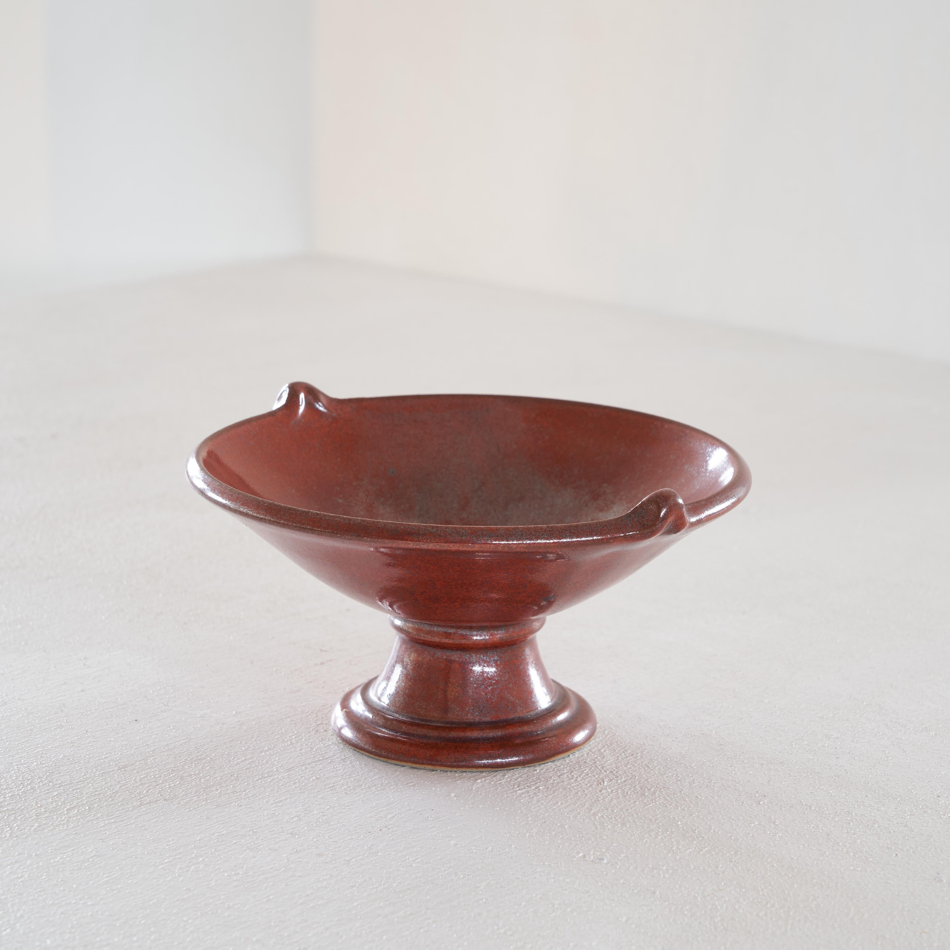 Red and gray speckled ceramic footed bowl

Very decorative and fun footed bowl in red and gray speckled glaze. Both the shape and the glaze are special. The classical footed design is complimented by the two joyful little sculpted handles and the