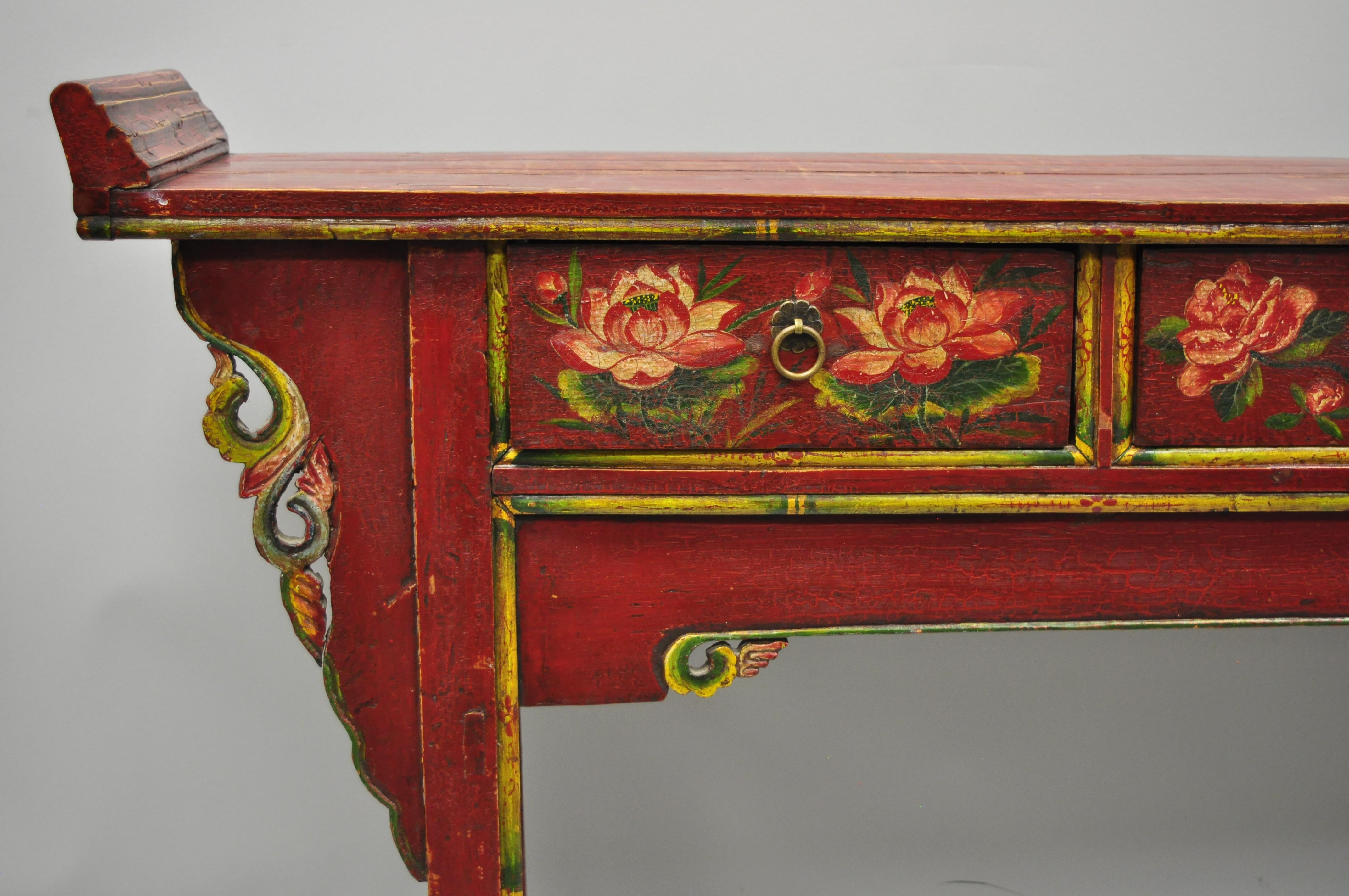 Mid-20th century red and green distress painted Mongolian buffet. Item features charming hand- painted floral design in reds, green and yellow, solid wood construction, and three dovetailed drawers, circa-mid 20th century. Measurements: Overall 37