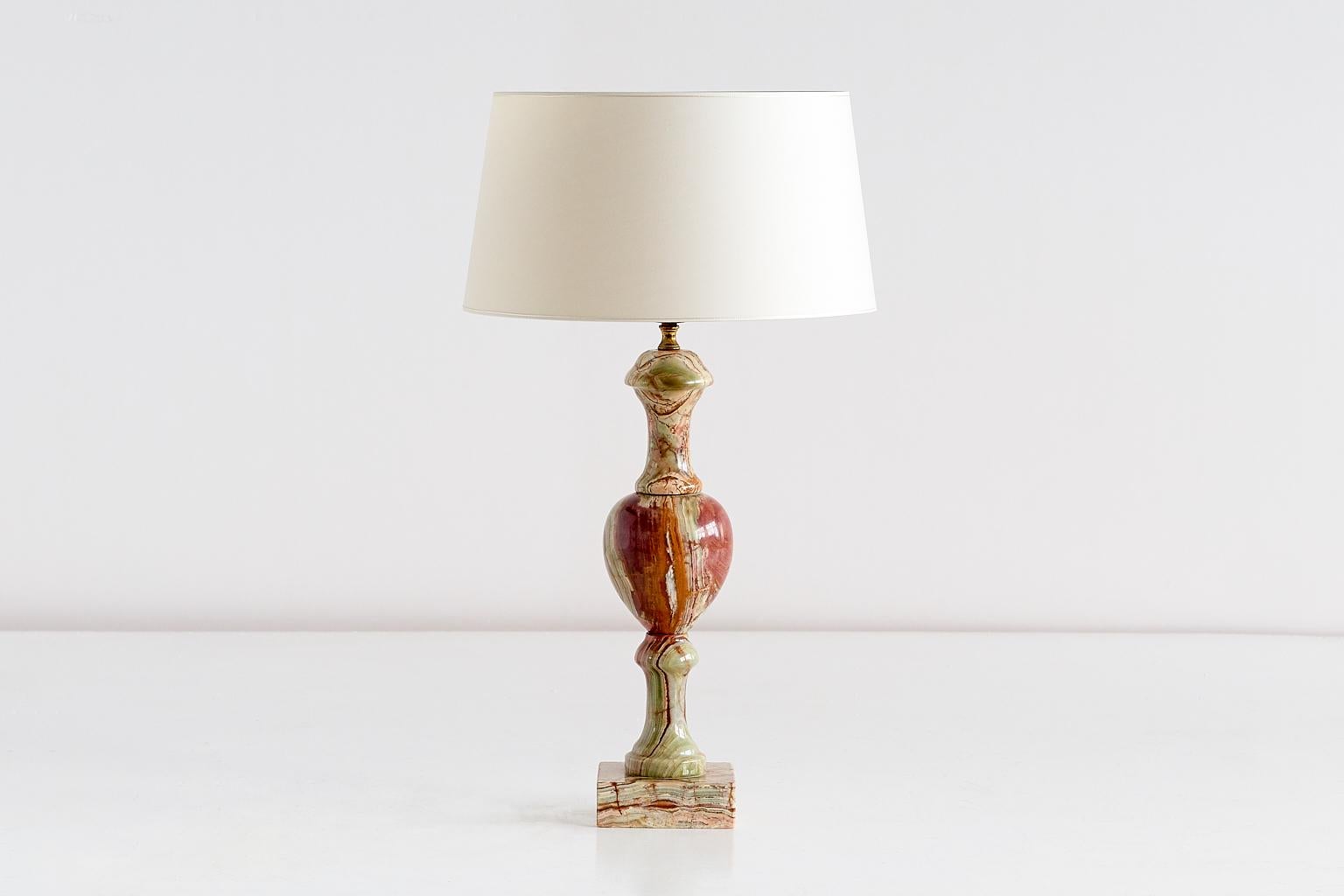 This elegant table lamp was produced in Italy in the late 1970s. The base is a combination of two columns and one oval shape, resting on a square foot, all in multicolored onyx. The contrasting veins of the red, white and green onyx give the lamp a