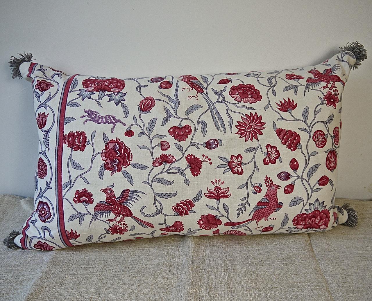 Early 20th century French linen cushion printed with stylized exotic birds and animals in raspberry red and pink with grey meandering branches and leaves. Vintage French grey cotton fringing on each corner. Self-backed and slip-stitched closed with