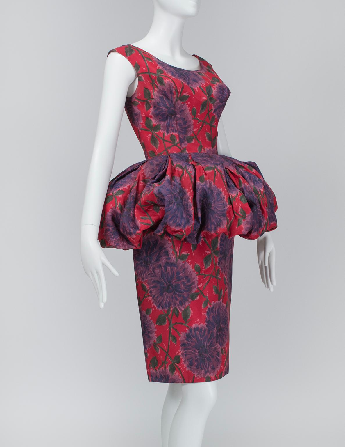Less a peplum and more a Renaissance-era farthingale, this dress's midsection uses an optical illusion to slim the waist and hips by comparison. Entrance- AND exit-making.

Vintage sleeveless sheath dress with wide scooping neckline and front and
