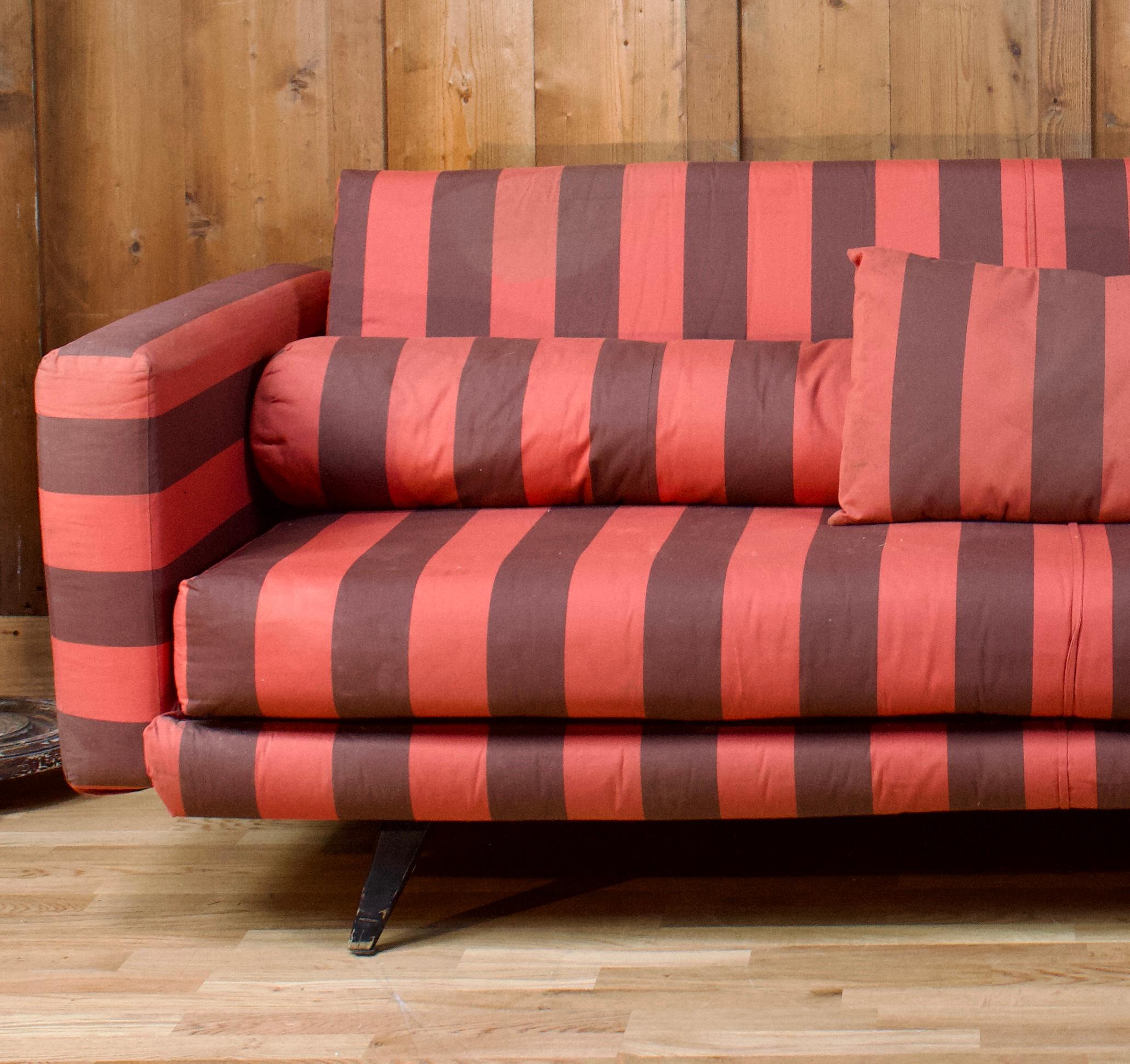 Nice vintage sofa in red and brown striped fabric from the 70s. This sofa has a vintage look and a design with clean lines allowing it to fit into a modern but also classic interior. The upholstery in very good condition in red and pale purple, was