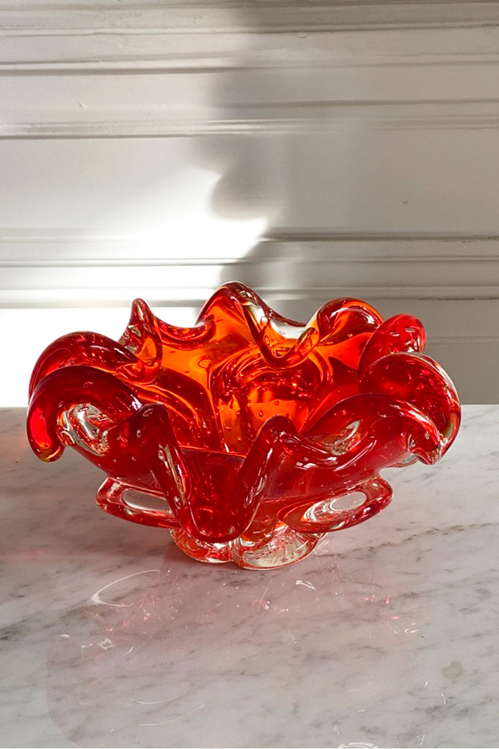 Schale aus rotem und durchscheinendem Muranoglas. Italien, 1950er Jahre.

Farben: Rouge und Gold.

Was ist Muranoglas? Wurde das Glas an einem besonderen Ort hergestellt? Oder mit speziellen Techniken hergestellt? Eigentlich ist es beides.
