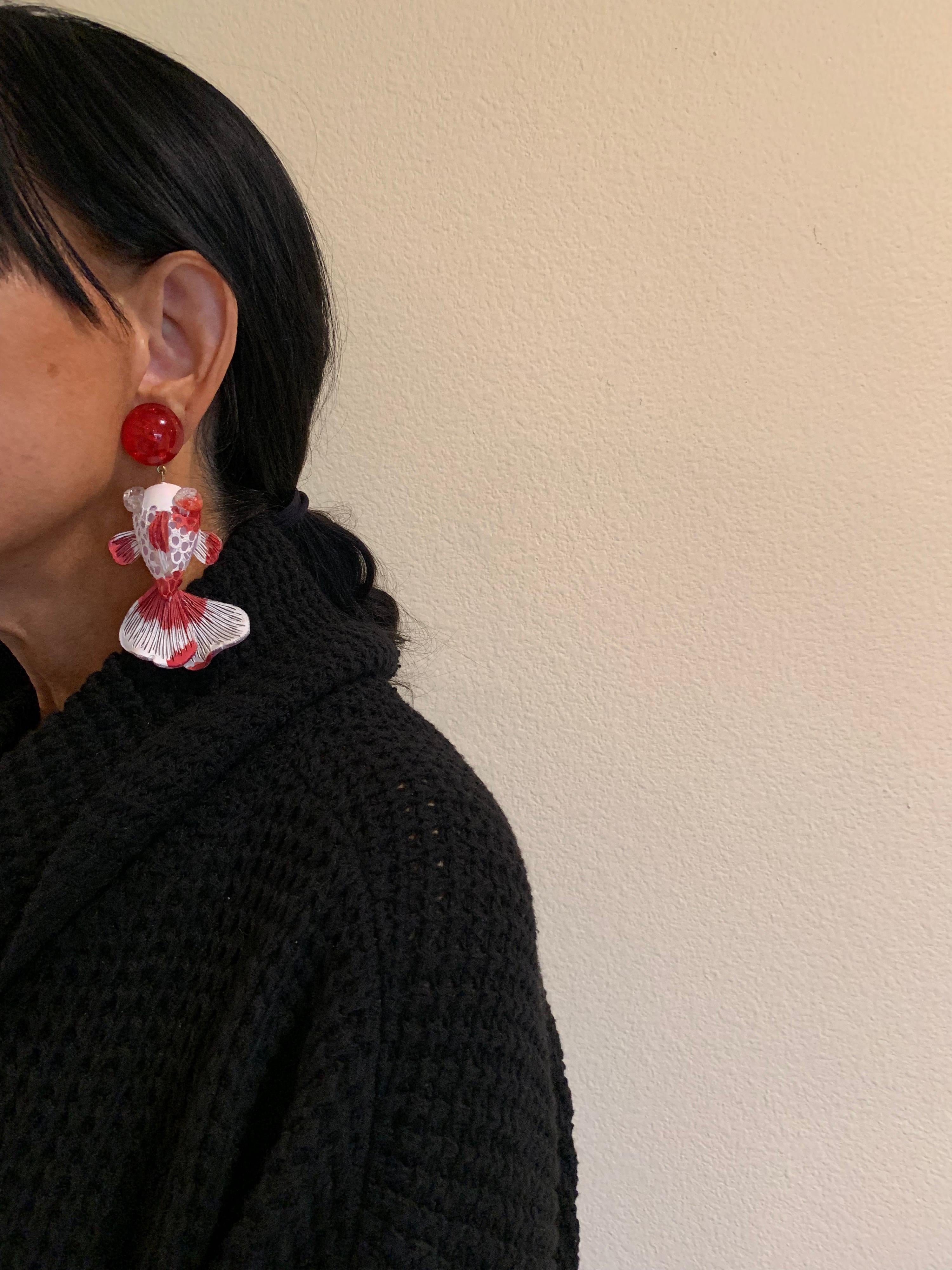 Light and easy to wear, these contemporary handmade artisanal clip-on earrings were made in Paris by Cilea. The lightweight statement earrings feature molded wave segments of enameline (enamel and resin composite) in red and white, depicting a koi