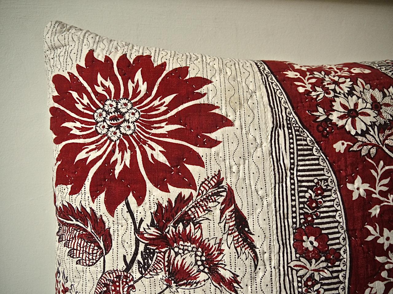 French circa 1790s block printed and quilted cotton cushion with a large-scale stylized floral and a patterned band design. A toile from Nantes or perhaps Beautiran. Fantastic crimson color contrasting with a soft white ground with a simple. Backed