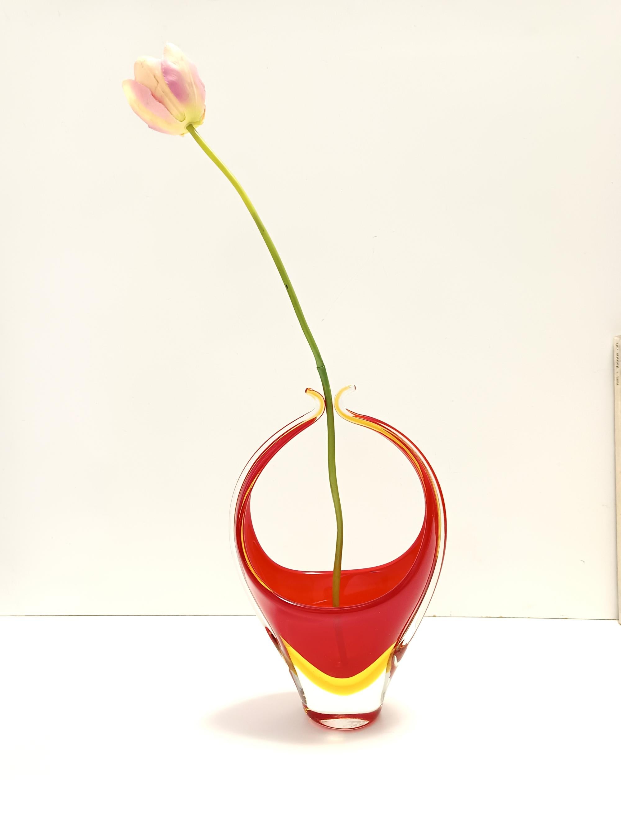 Made in Italy, 1960s. 
This vase is made in Sommerso Murano glass, which has been hand blown with three different colors: transparent, red and yellow.
It is a vintage item, therefore it might show slight traces of use, but it can be considered as in